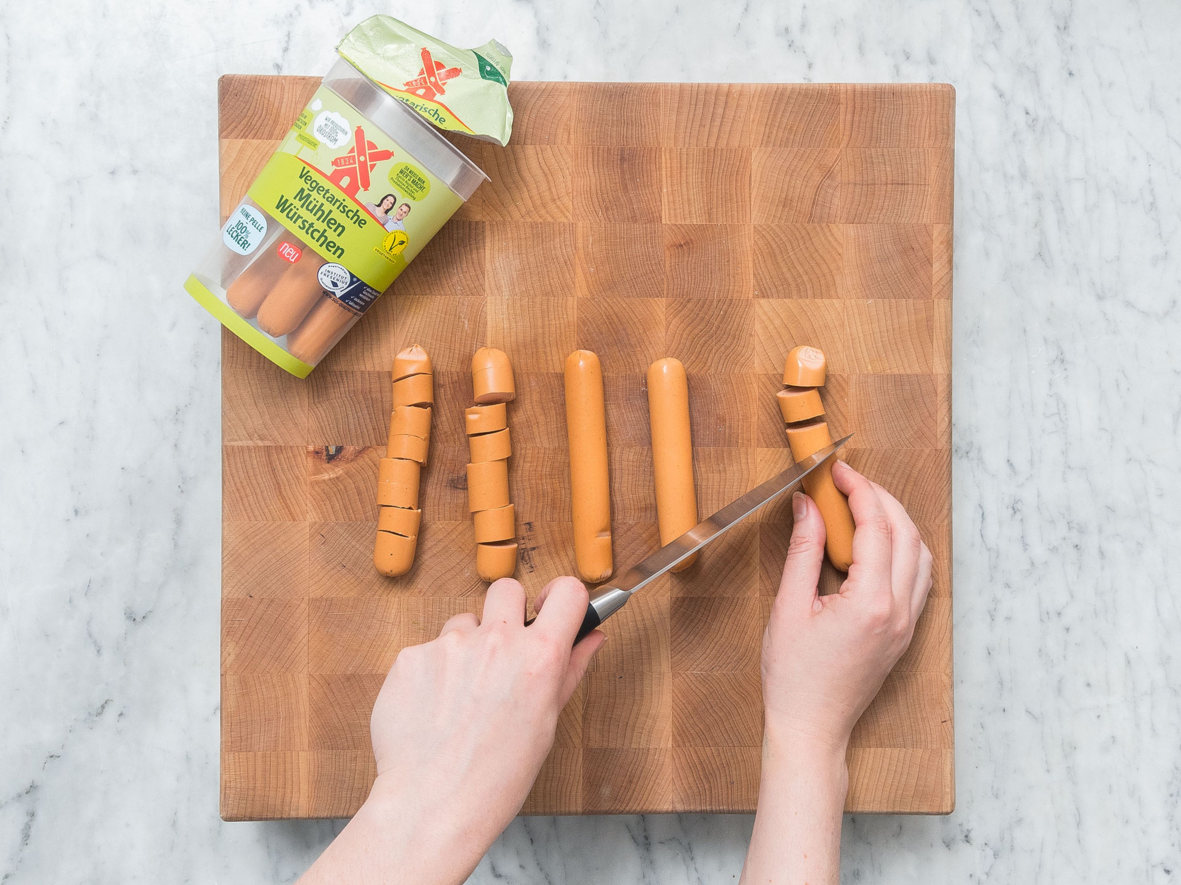 Slice vegetarian sausages. Heat oil in a frying pan and fry slices for approx. 4 – 5 min.