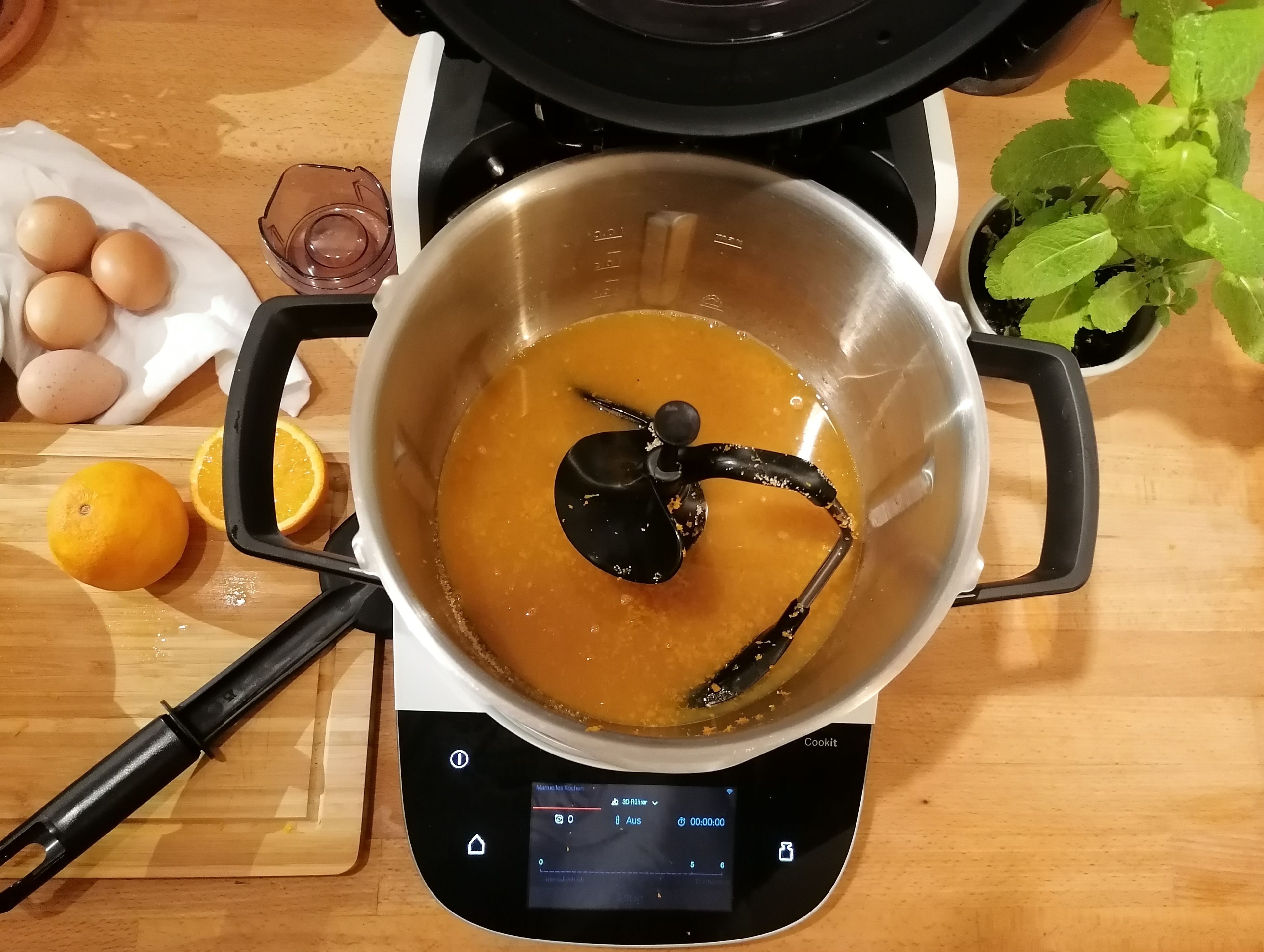 Für das Orangencurd den 3D-Rührer einsetzen. Die Schale der Orangen abreiben und mit Orangensaft und Zucker im Topf, bei geschlossenem Deckel und eingesetzten Messbecher, vermengen (3D-Rührer | Stufe 6 | 25 Sekunden). Die Speisestärke mit dem restlichen Orangensaft in einer seperaten Schüssel glatt rühren und gemeinsam mit den Eiern und der Butter in den Cookit geben. Alles bei geschlossenem Deckel ohne Messbecher erhitzen (3D-Rührer | Stufe 5 | 96°C | 25 Minuten). 
Wenn das Orangencurd fertig ist, in eine Schüssel geben und den Cookit säubern.