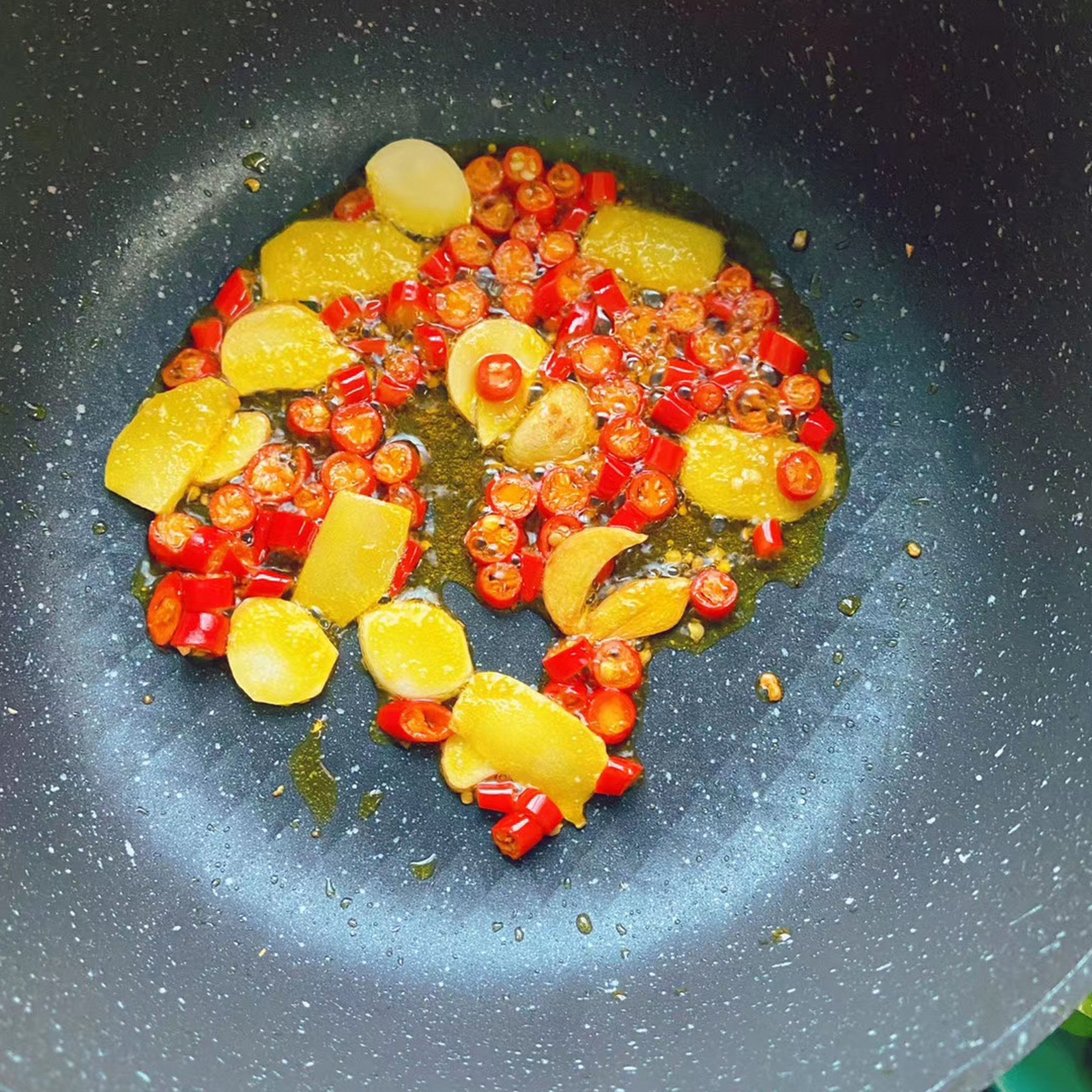 Add canola oil to a frying pan and sauté ginger, garlic and fresh chilis.