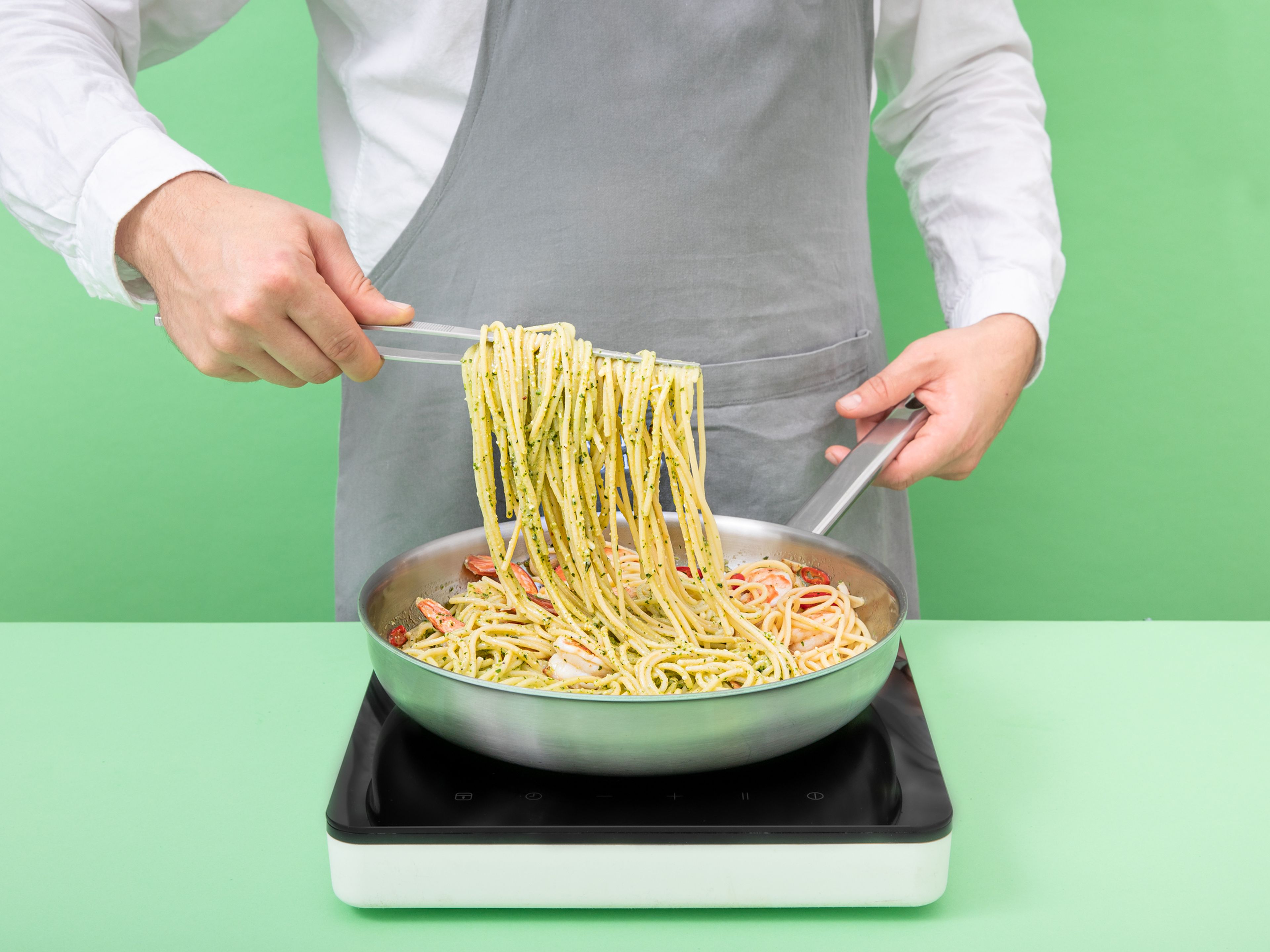 Gekochte Spaghetti und Pesto vermischen. Dabei Nudelwasser hinzufügen, bis eine cremige Konsistenz entsteht. Pasta auf Teller aufteilen. Mit Riesengarnelen, Ofentomaten und etwas frischen Rucola servieren. Guten Appetit!