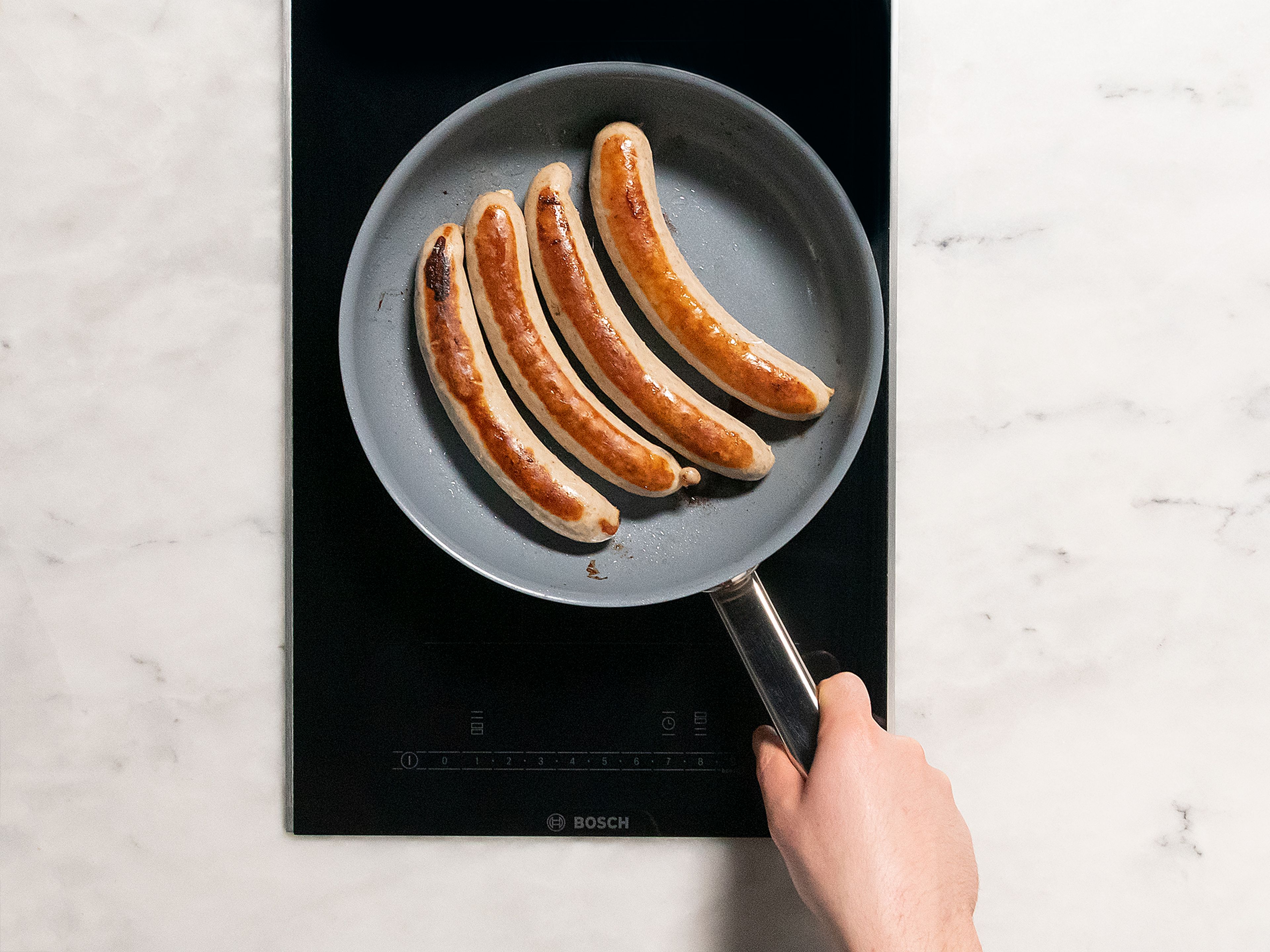 Add a generous amount of vegetable oil to a frying pan. Add sausages and fry until they are golden brown on all sides. Cut sausages into smaller pieces and generously pour the sauce all over. Top with more curry powder. Enjoy!