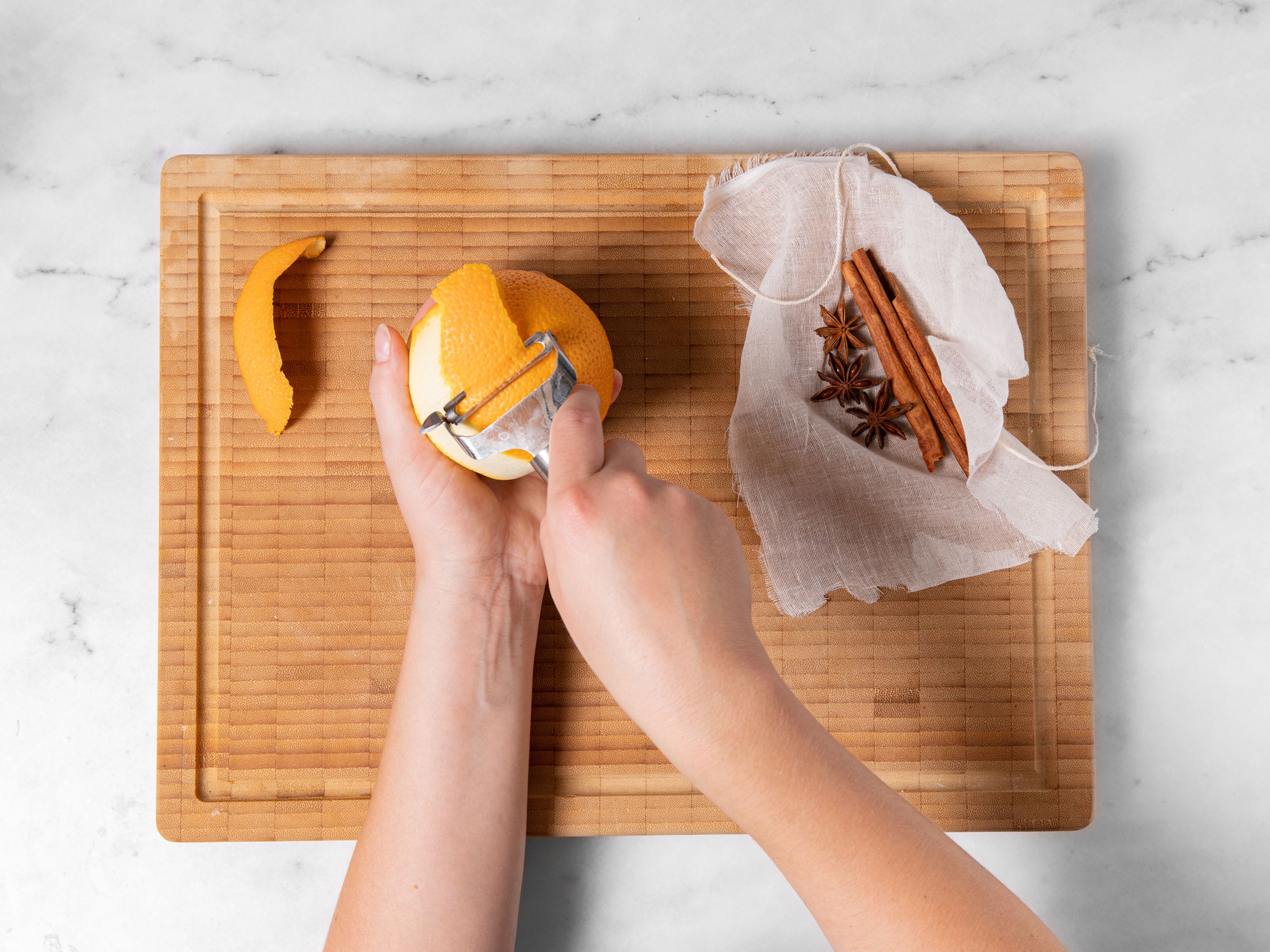 Use a vegetable peeler to peel 2 large pieces of zest from the orange. Use a paring knife to remove any white pith. Add orange zest, star anise, and cinnamon to a piece of cheesecloth and secure with kitchen twine.