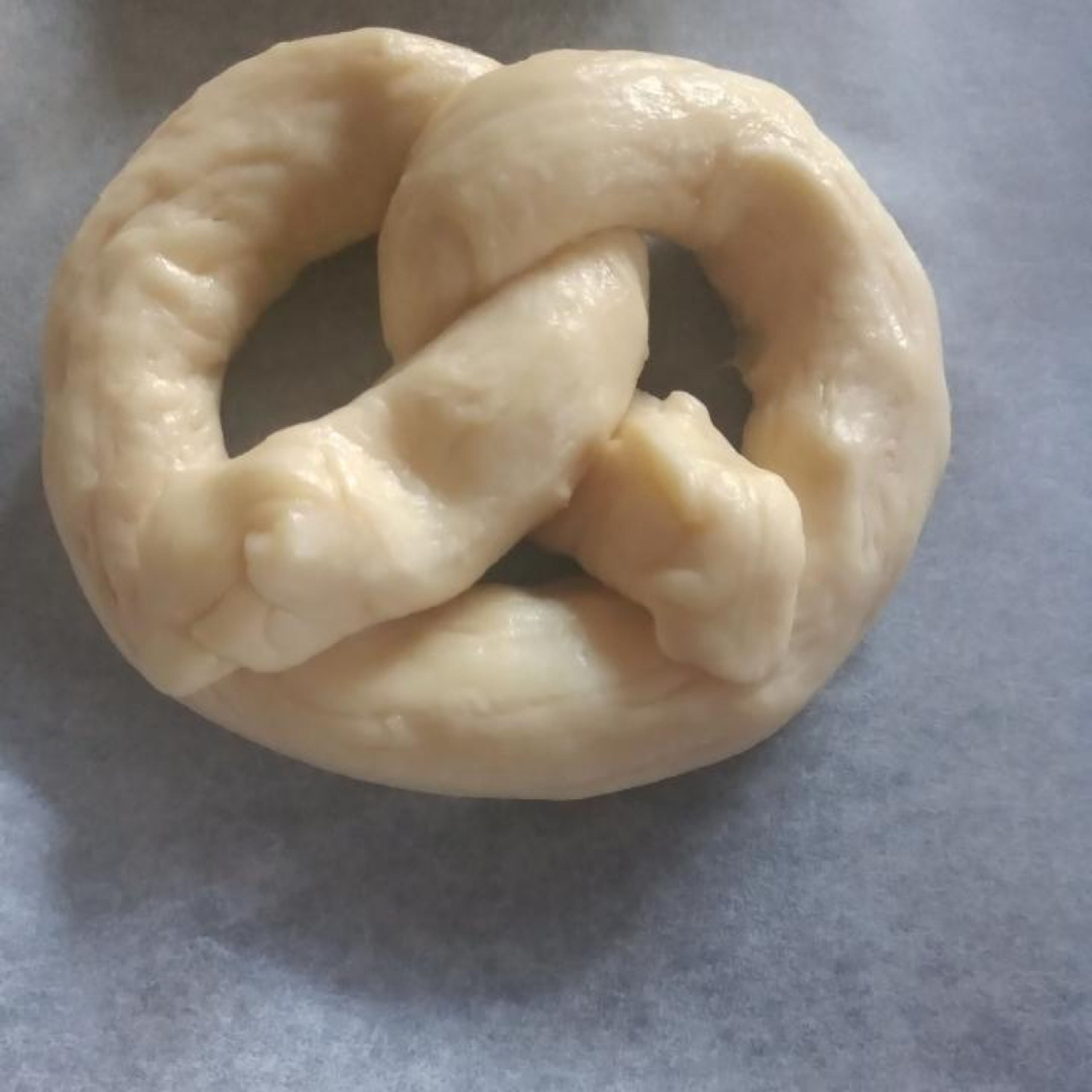 Shape into pretzels by making a horseshoe facing away from you, twisting the 2 sides together and placing the ends on the part nearest to you.