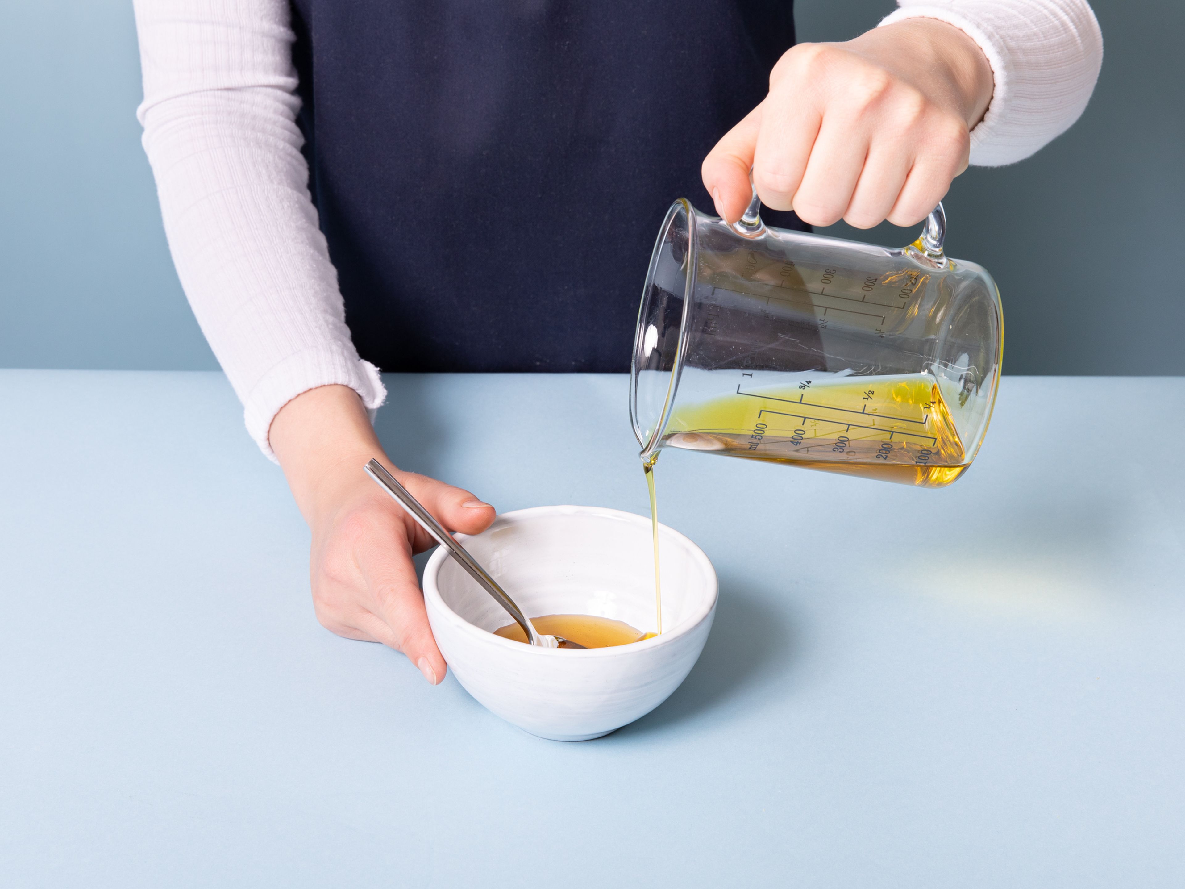 Das restliche Olivenöl in eine weitere Schüssel geben. Nun Honig und Saft der restlichen Zitronen hinzugeben. Mit Salz und Pfeffer abschmecken und beiseite stellen.