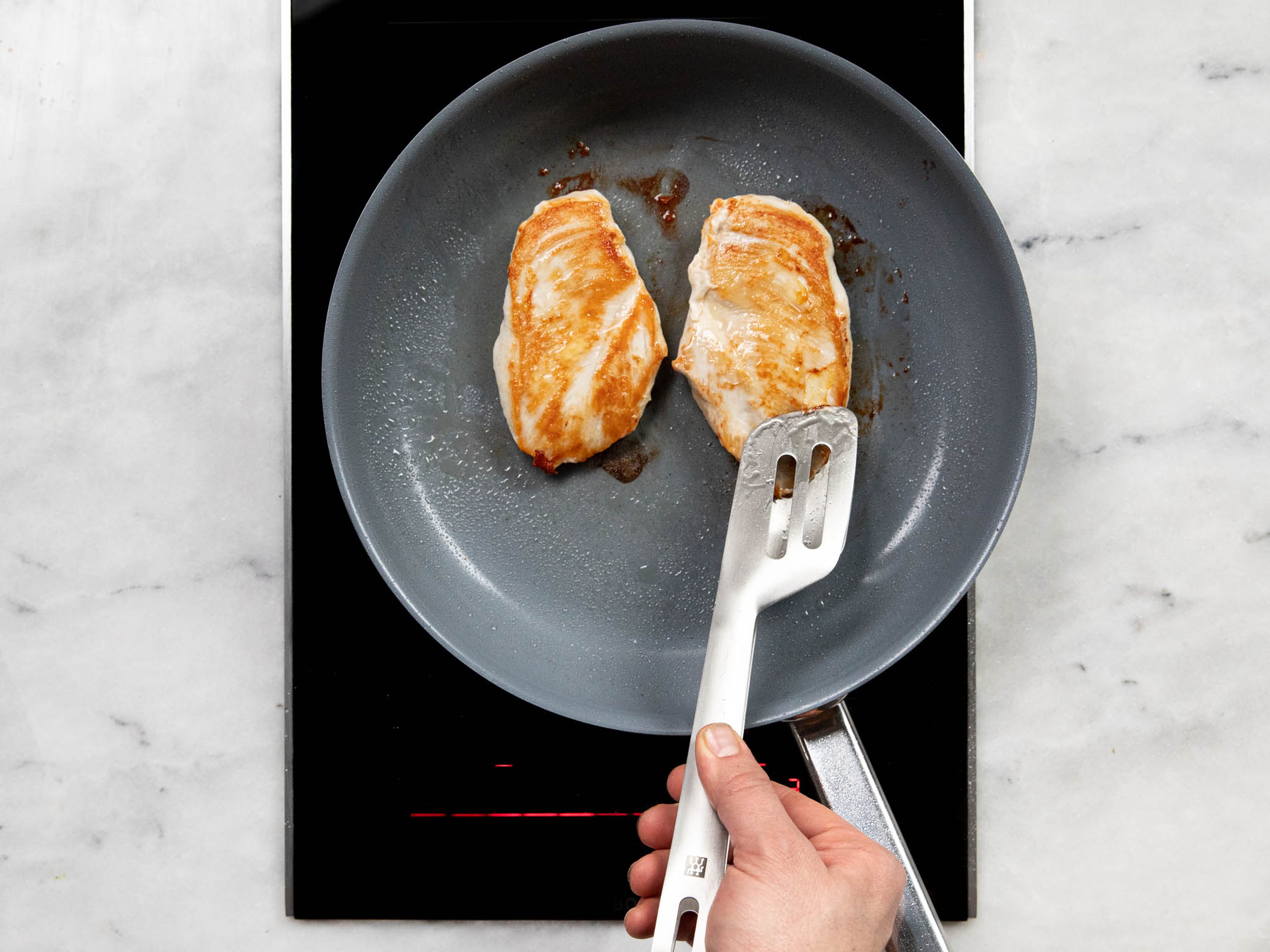 Heat a frying pan over medium heat. Add vegetable oil and fry chicken breasts for approx. 4 min., then flip and fry another 4 min., or until cooked through. Season with salt and pepper. Remove, let cool for a few minutes, then slice.