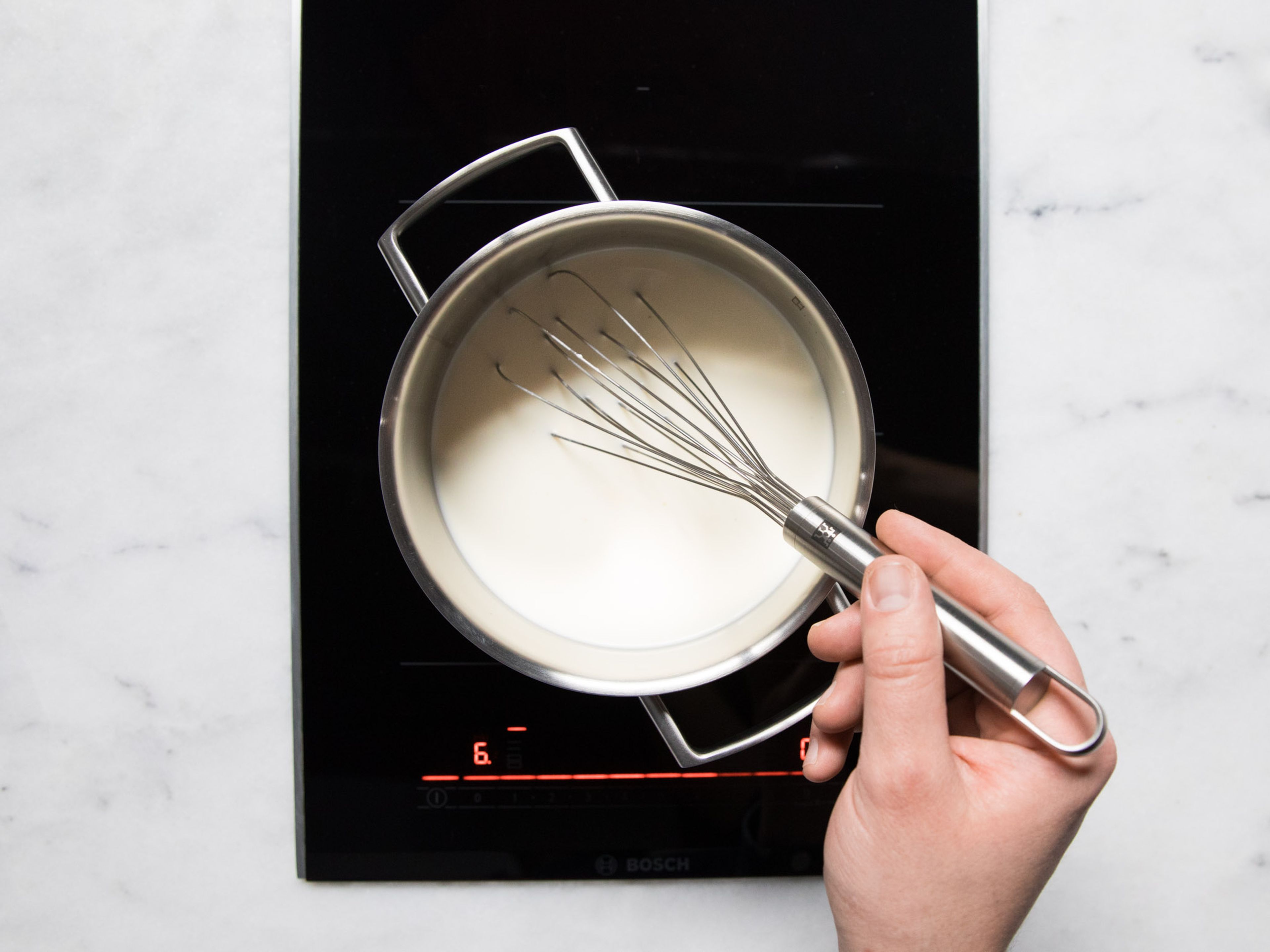Add remaining milk, sugar, and heavy cream to a pot over medium heat and stir to combine. Stir in milk and starch mixture and heat until the mixture thickens. Stir constantly to prevent any lumps from forming.