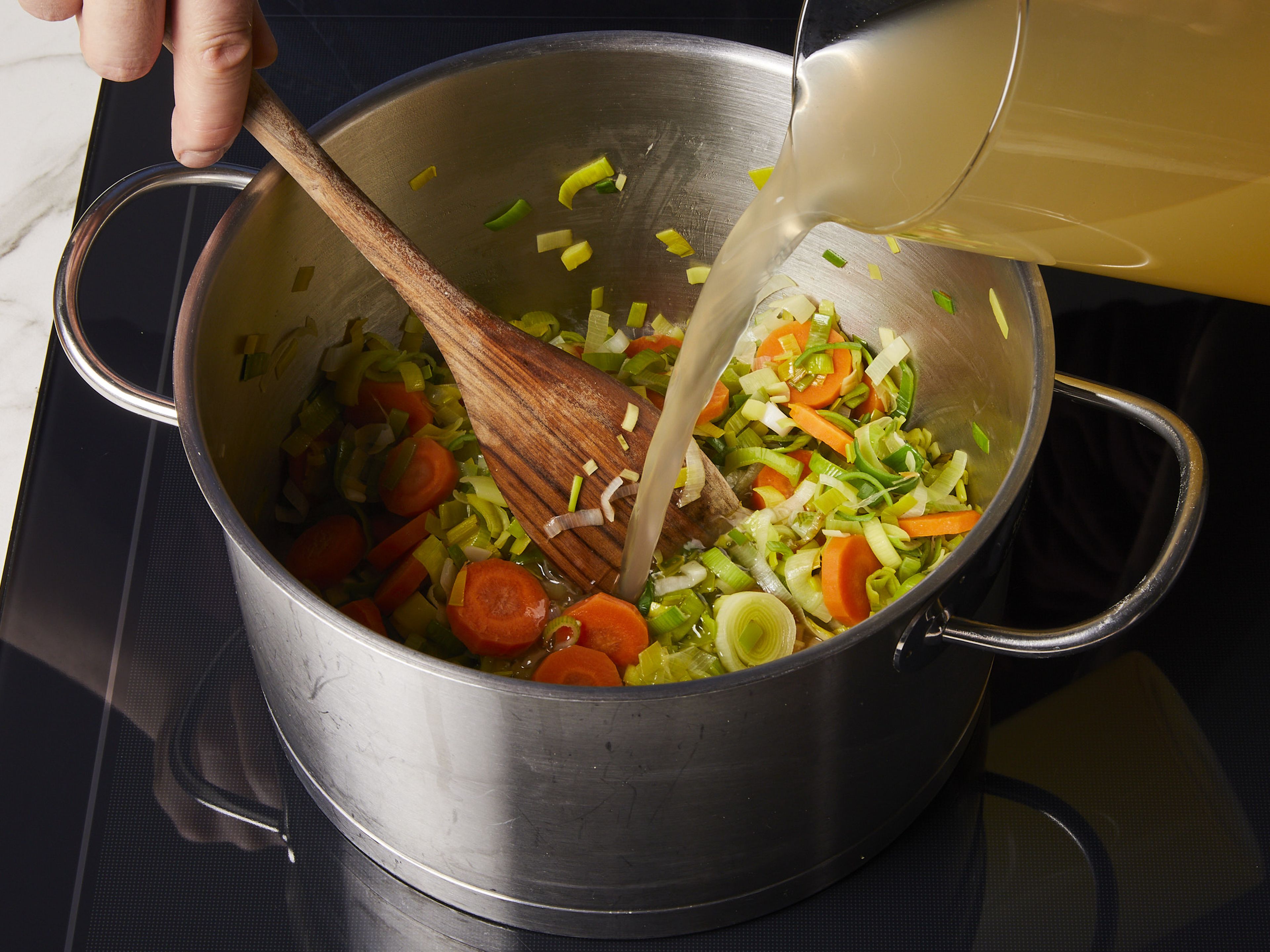 In a large pot, sauté leeks and carrot in butter for approx. 1–2 min. until the leeks are translucent and reduced in volume by half. Add potatoes and fish stock. Season with salt and pepper. Let it simmer over medium heat for approx. 10 min. until the potatoes are cooked through.