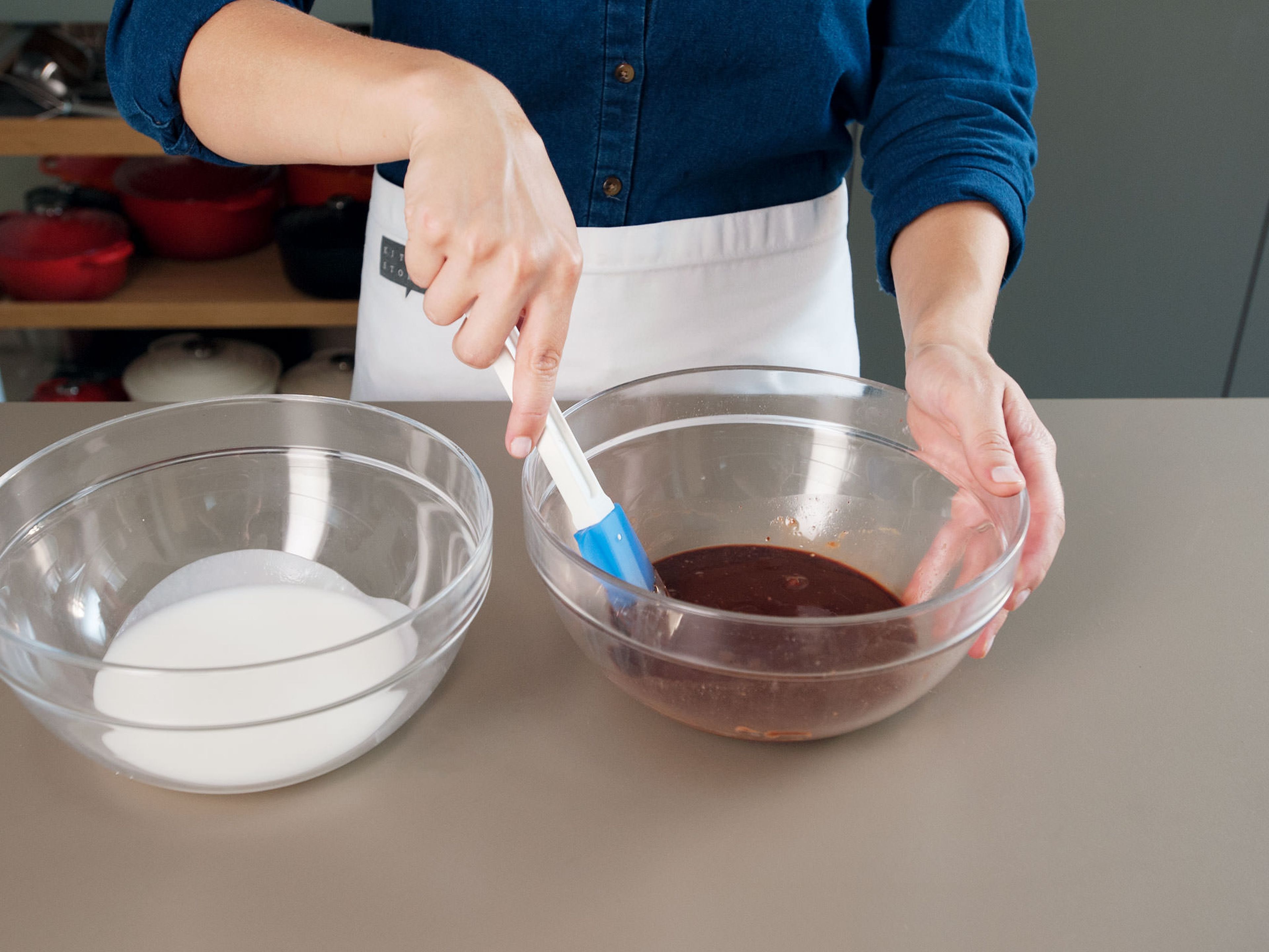 Für den Zuckerguss in einer kleinen Schüssel Puderzucker und löffelweise heißes Wasser miteinander vermischen, bis eine dickflüssige Glasur entsteht. Im Wasserbad Schokolade schmelzen lassen. Vom Herd nehmen. Anschließend, die Hälfte des Zuckerguss in einer sauberen Schüssel mit dem Kakaopulver und der geschmolzenen Schokolade vermengen. Wenn nötig, esslöffelweise heißes Wasser hinzufügen.