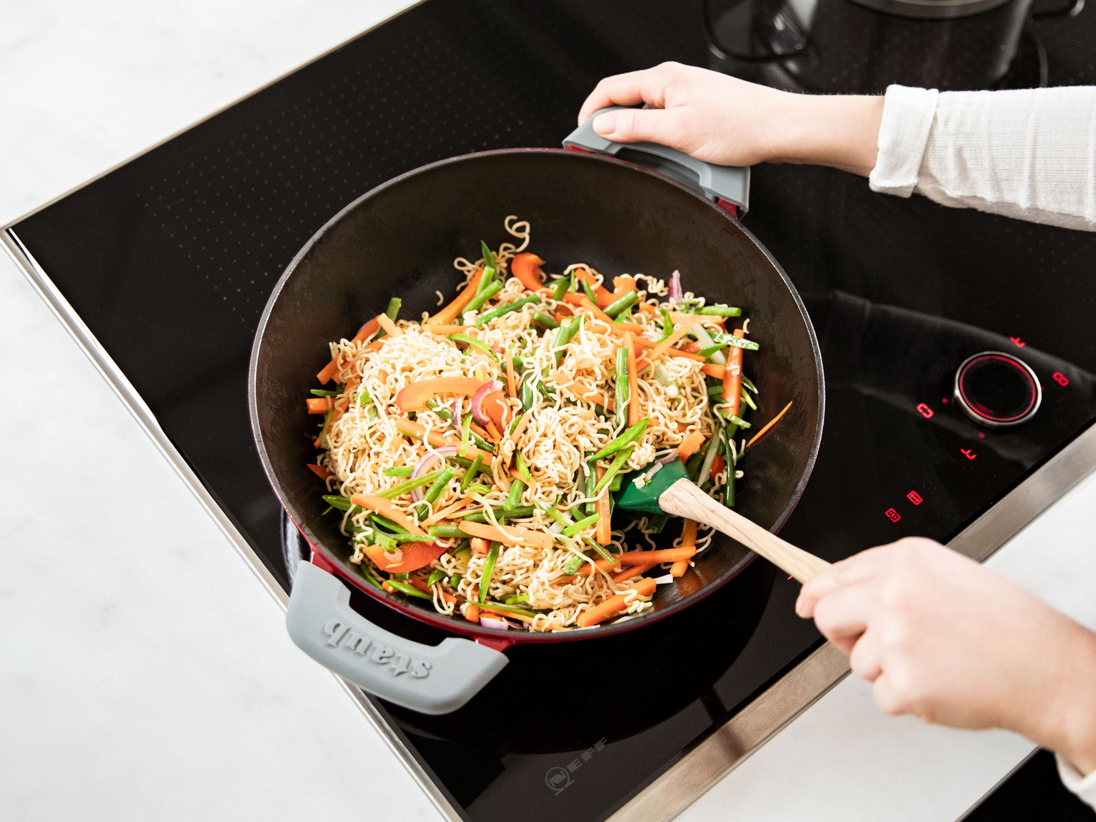 Heat sesame oil in a wok, add the noodles, and stir-fry on high heat until browned, approx. 4 min. Add the vegetables to the noodles and fry approx. 5 - 7 min, tossing often.