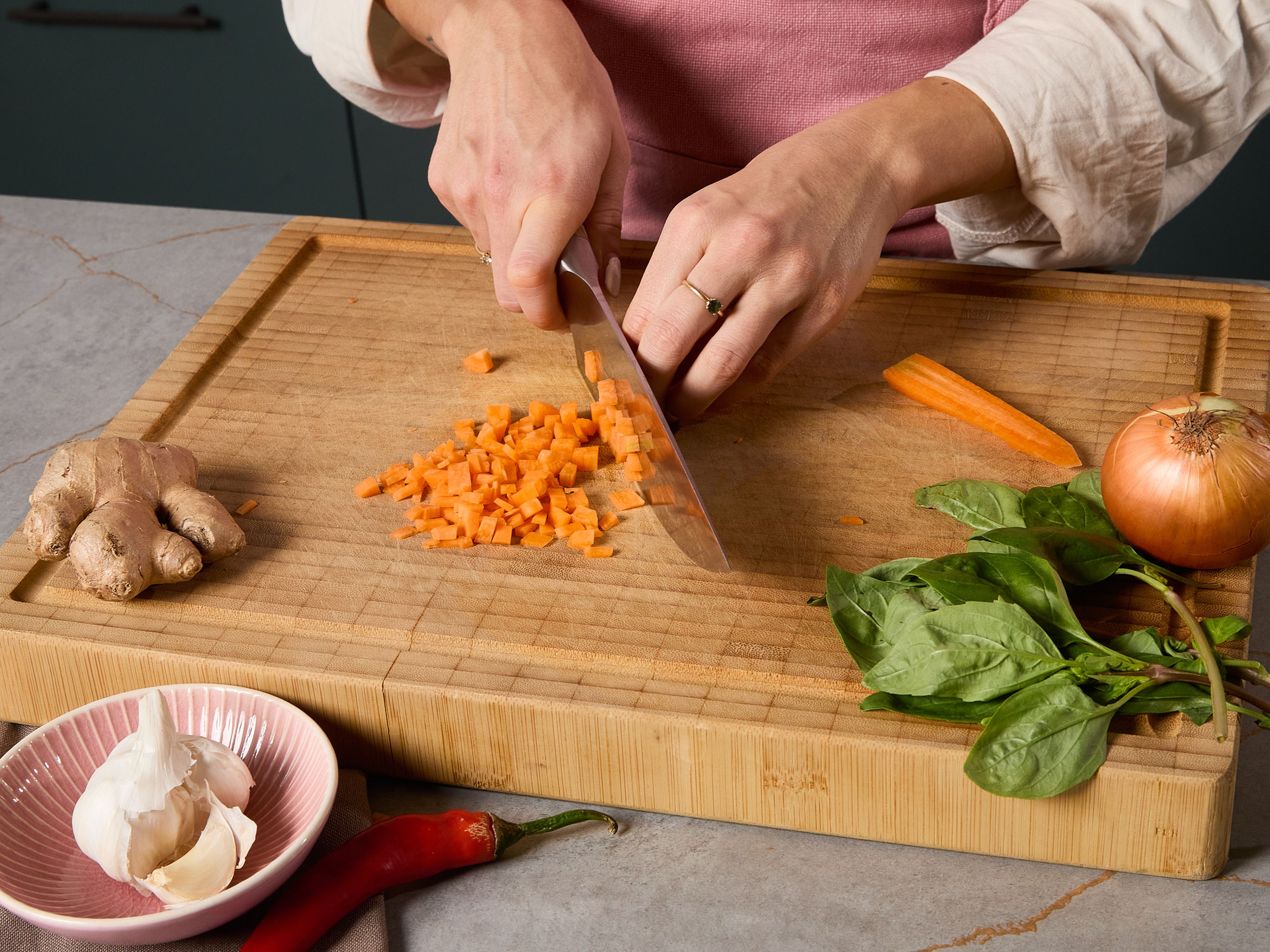 Peel the carrot and cut it into fine cubes. Also peel the onion and garlic; finely dice the onion and finely chop the garlic. Peel and finely grate the ginger. Halve the red chili pepper, deseed it, and cut it into fine slices.
