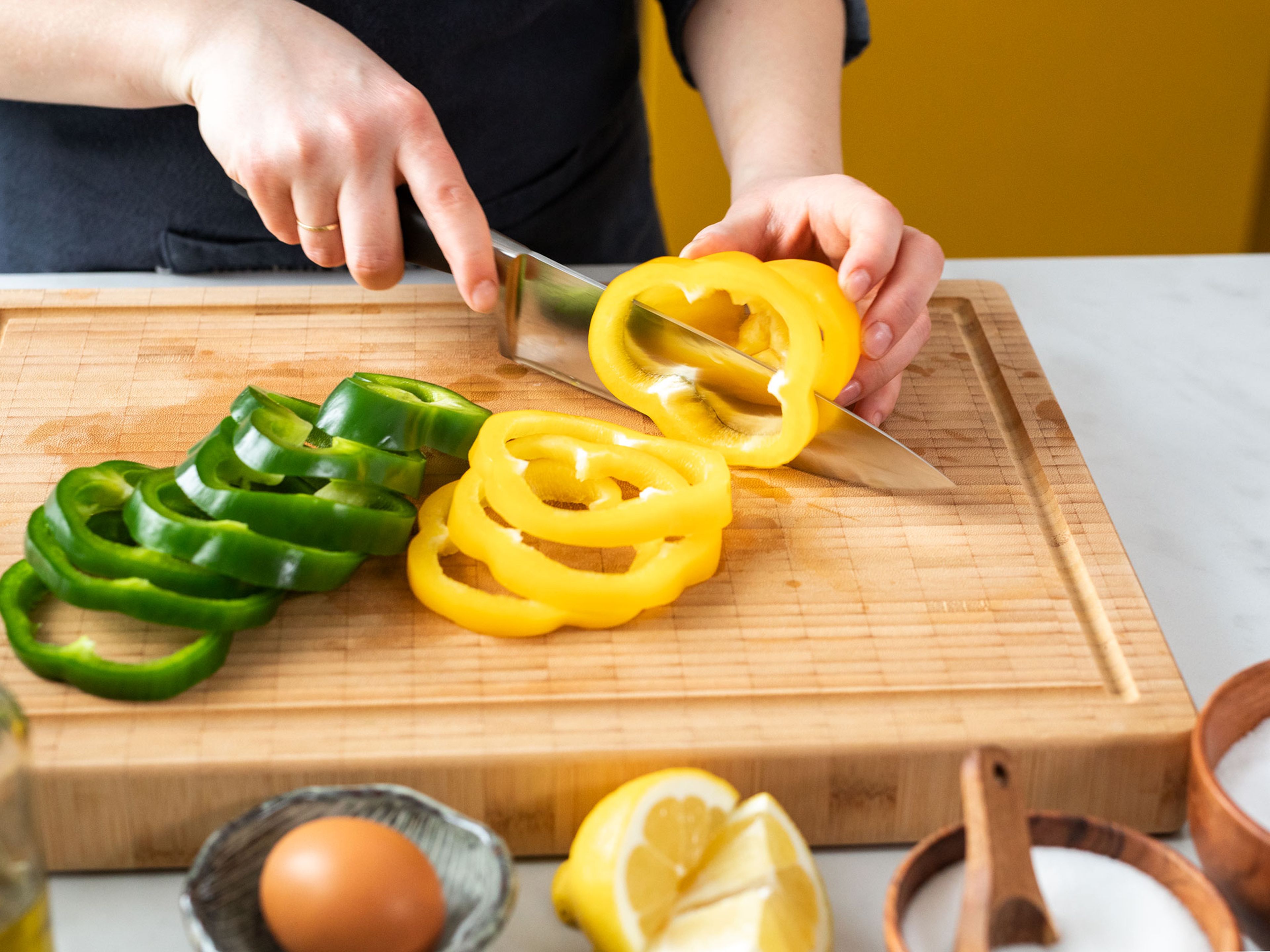 Den Backofen auf 220°C vorheizen. Stängel und Kerngehäuse der Paprika entfernen. Paprika in ca. 0,5 cm – 1 cm dicke Scheiben schneiden.