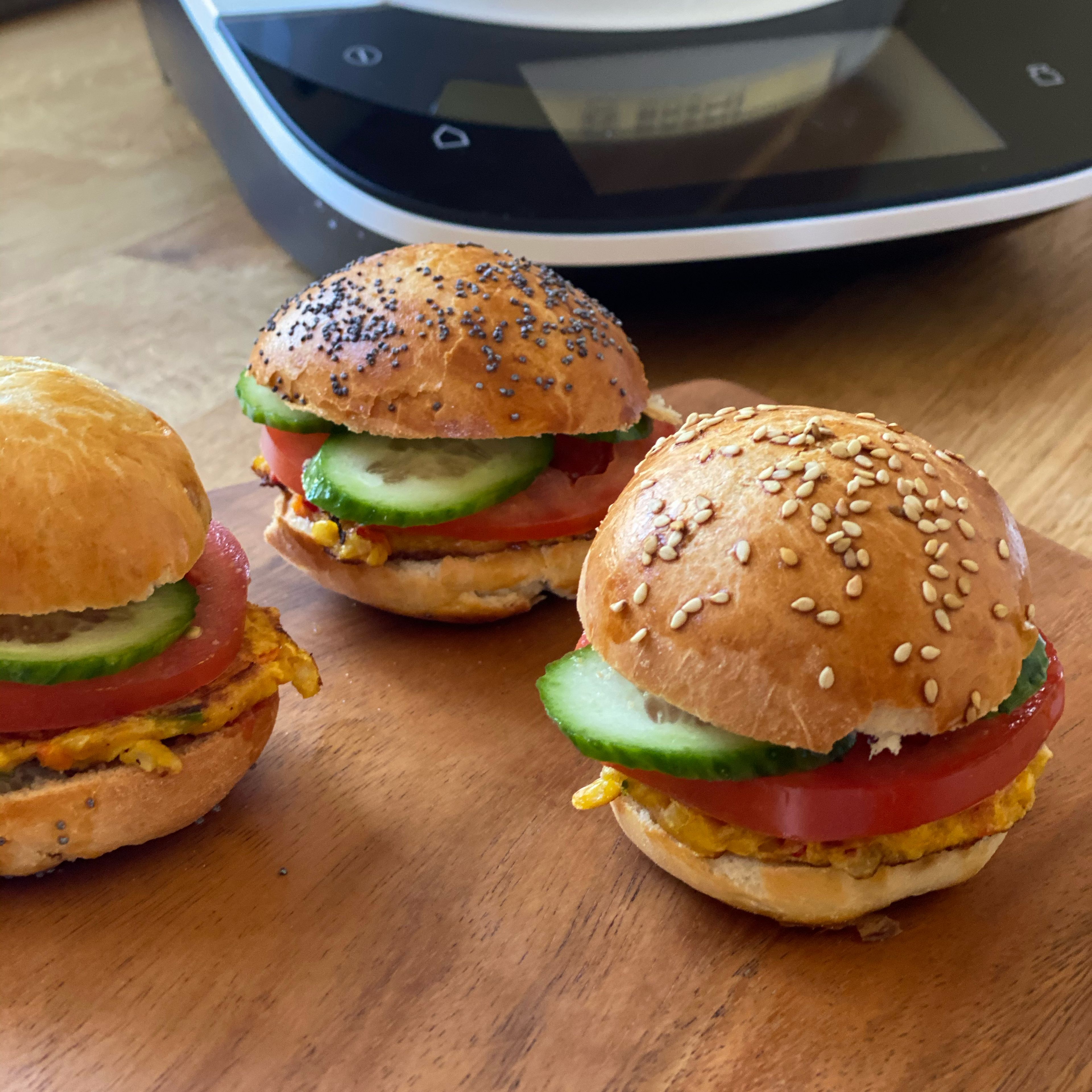 Die Burger Buns halbieren, Mit Ketchup und Mayonnaise bestreichen, Mais-Paprika-Patty aufsetzen, mit Tomatenscheiben und Gurkenscheiben belegen. Evtl mit Burgerspiesse fixieren,