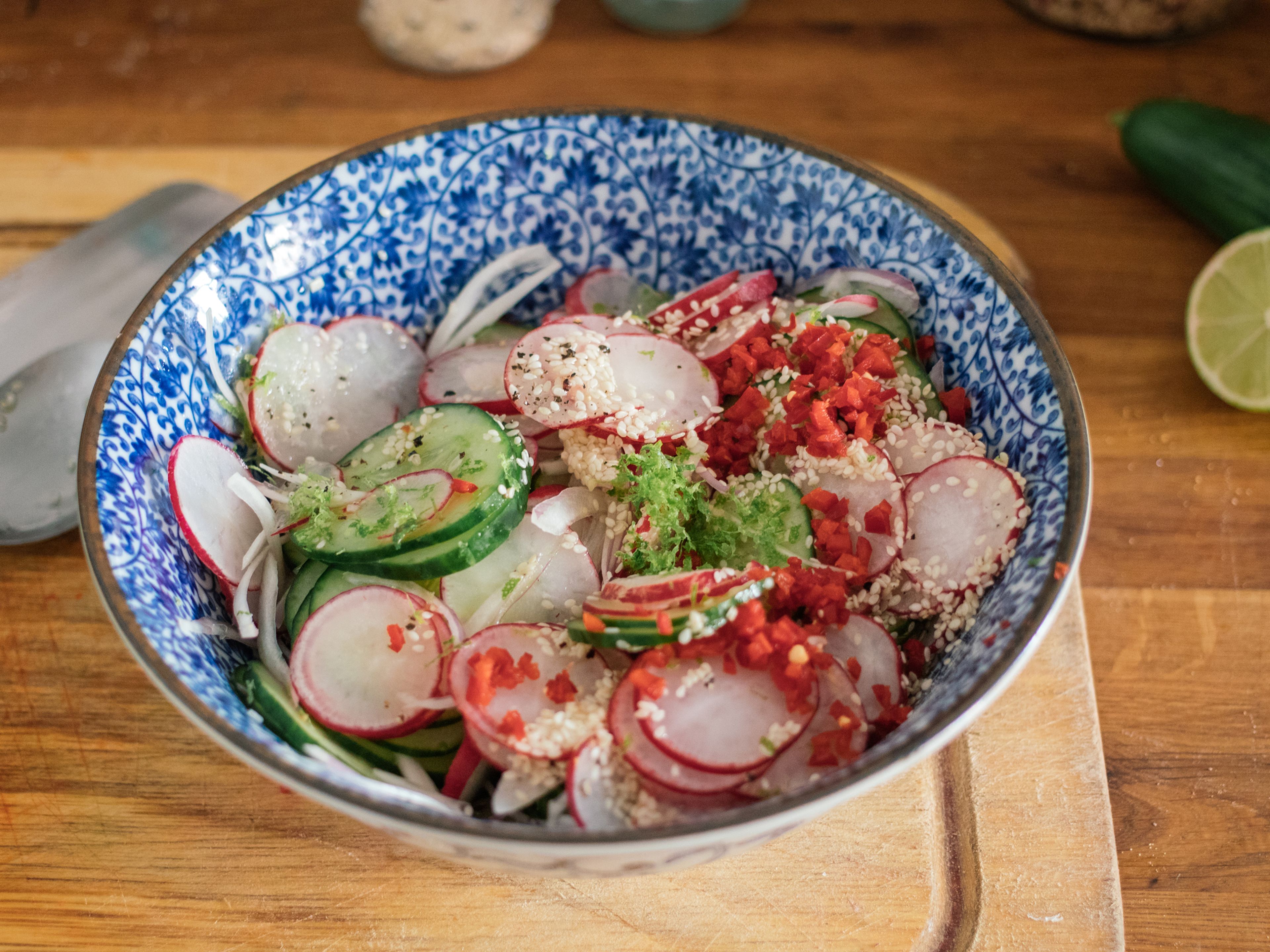 In the meantime, thinly slice cucumber, radishes, and shallot. Add rice vinegar, zest and juice of half of a lime, finely chopped chili, peanut oil, soy sauce, and sesame seeds to a large bowl. Stir to combine and season with salt and pepper to taste. Add cut vegetables, mix with dressing, and let sit until serving.