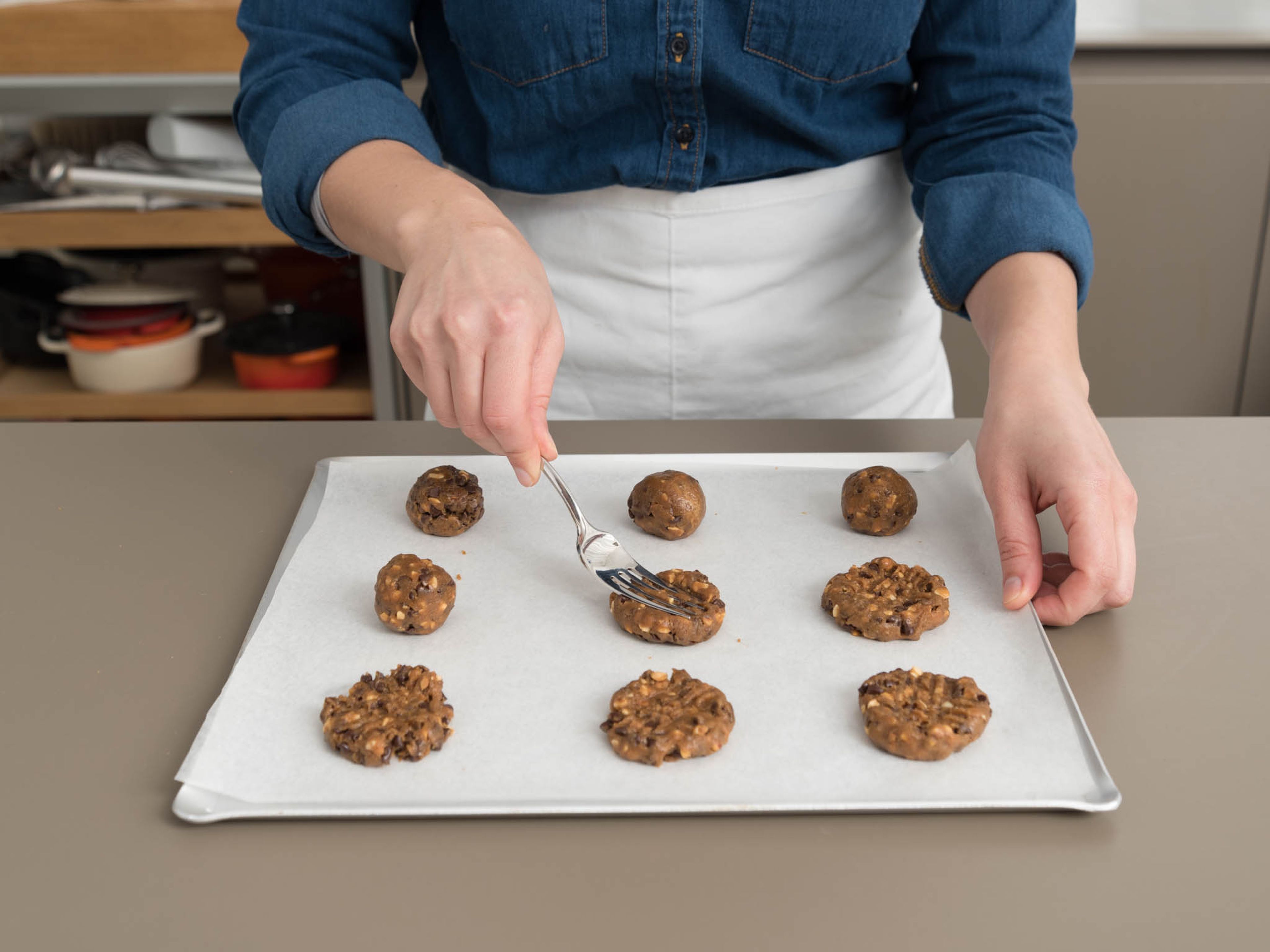 Scoop dough into equal-sized balls and place on parchment paper-lined baking sheets, spacing balls about 5 cm/2 in. apart. Use fork tines to flatten and make crisscross marks on cookies. Sprinkle with flaky sea salt, if desired.