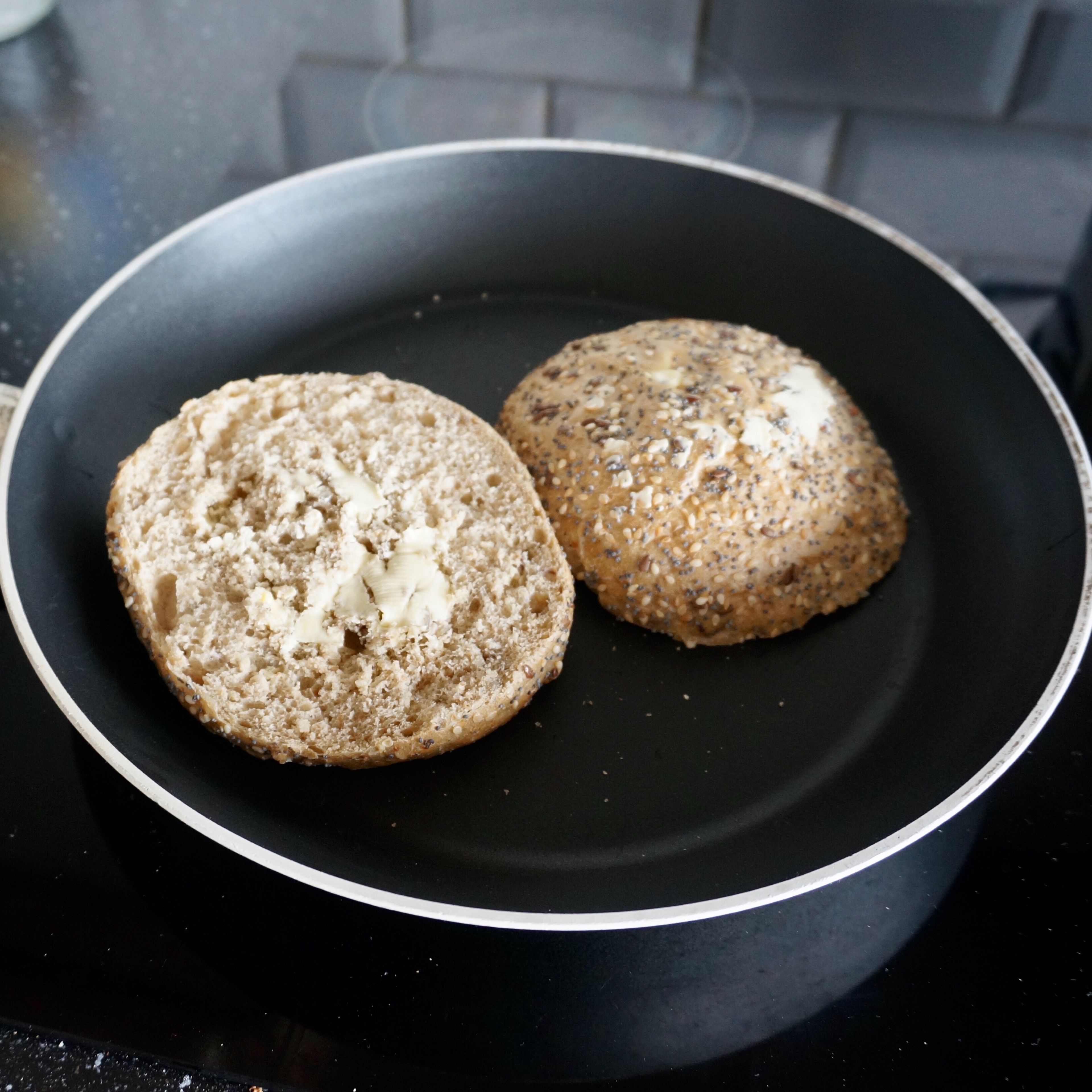 Cut the wheat bun, spread bread with butter on both sides and fry in a preheated pan.