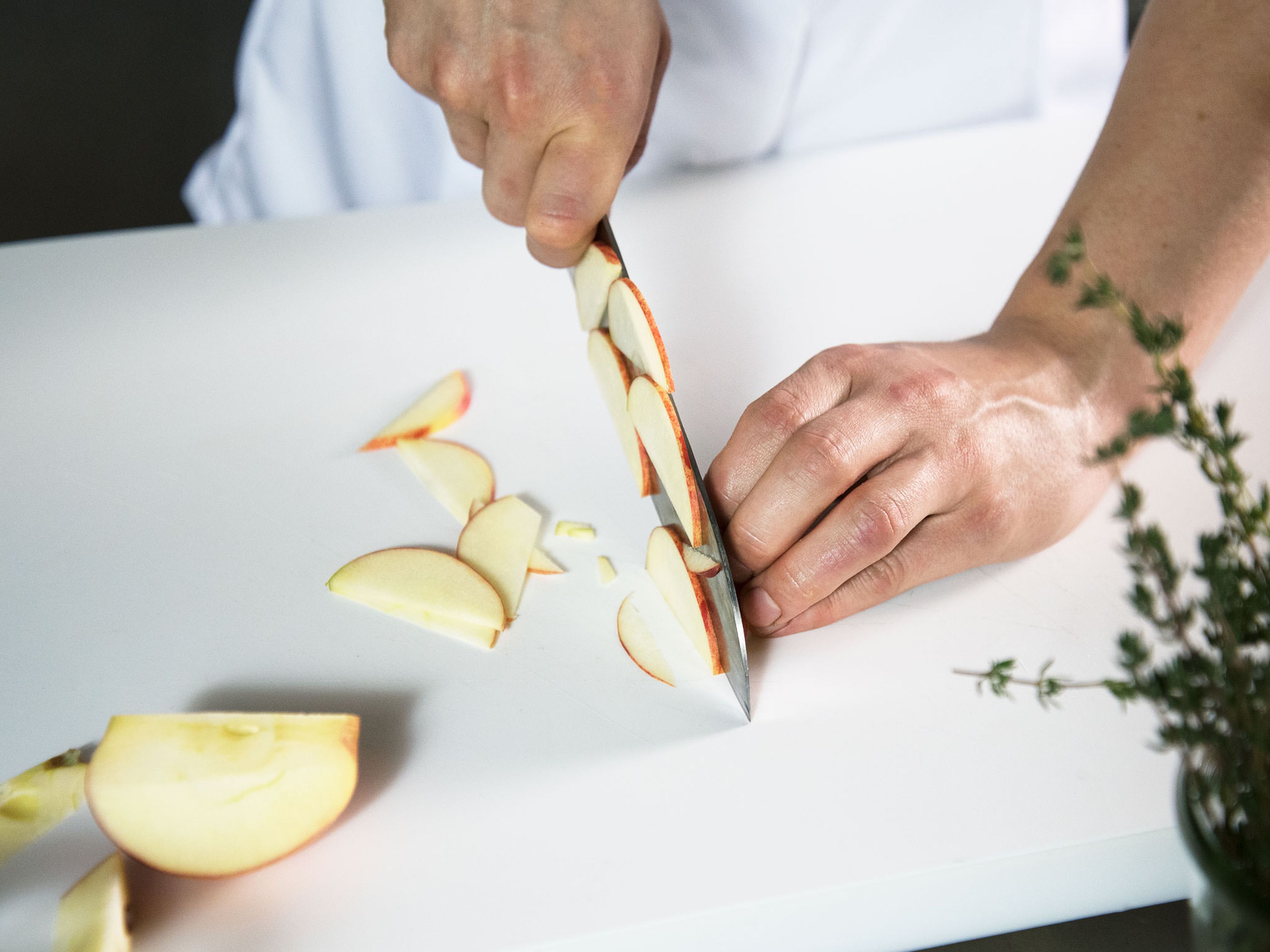 Apfel vierteln, Kerngehäuse entfernen und in dünne Scheiben schneiden. Apfelscheiben direkt in das vorbereitete Dressing legen, damit sie sich nicht bräunlich färben. Karotte schälen und grob raspeln.