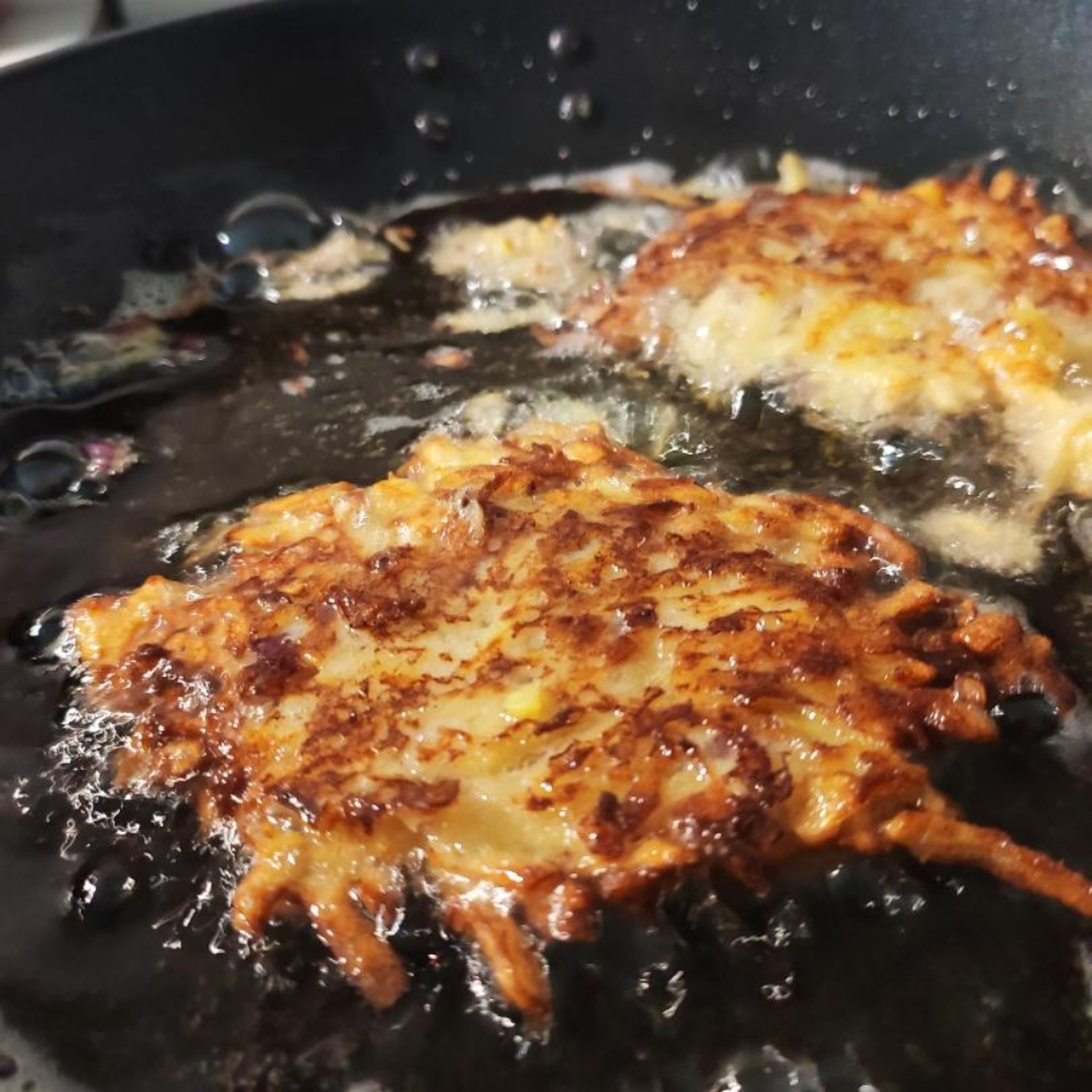 Kartoffelpuffer im Öl braten, bis sie von beiden Seiten goldbraun sind. Dann auf einem Küchenpapier abtropfen und abkühlen lassen, aber essen, bevor sie kalt sind!