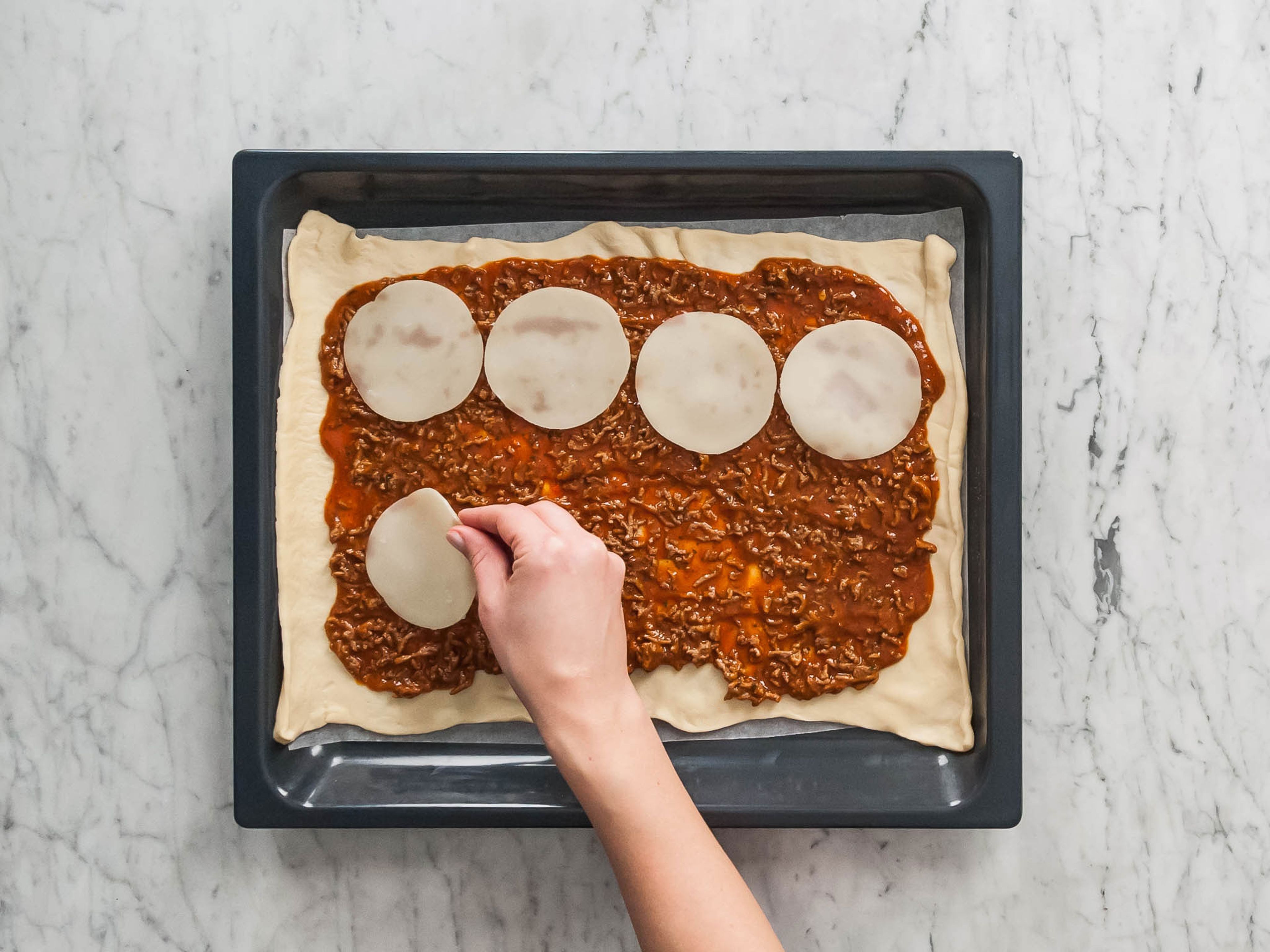 Pizzateig auf einem mit Backpapier belegten Backblech ausrollen. Bolognese darauf verteilen und dabei etwas Platz an den Rändern lassen. Zuerst die Provolone Scheiben und dann die Salami darauflegen und den Mozzarella darüber verteilen. Teig an den kurzen Seiten etwas einklappen und dann von der langen Seite aufrollen.