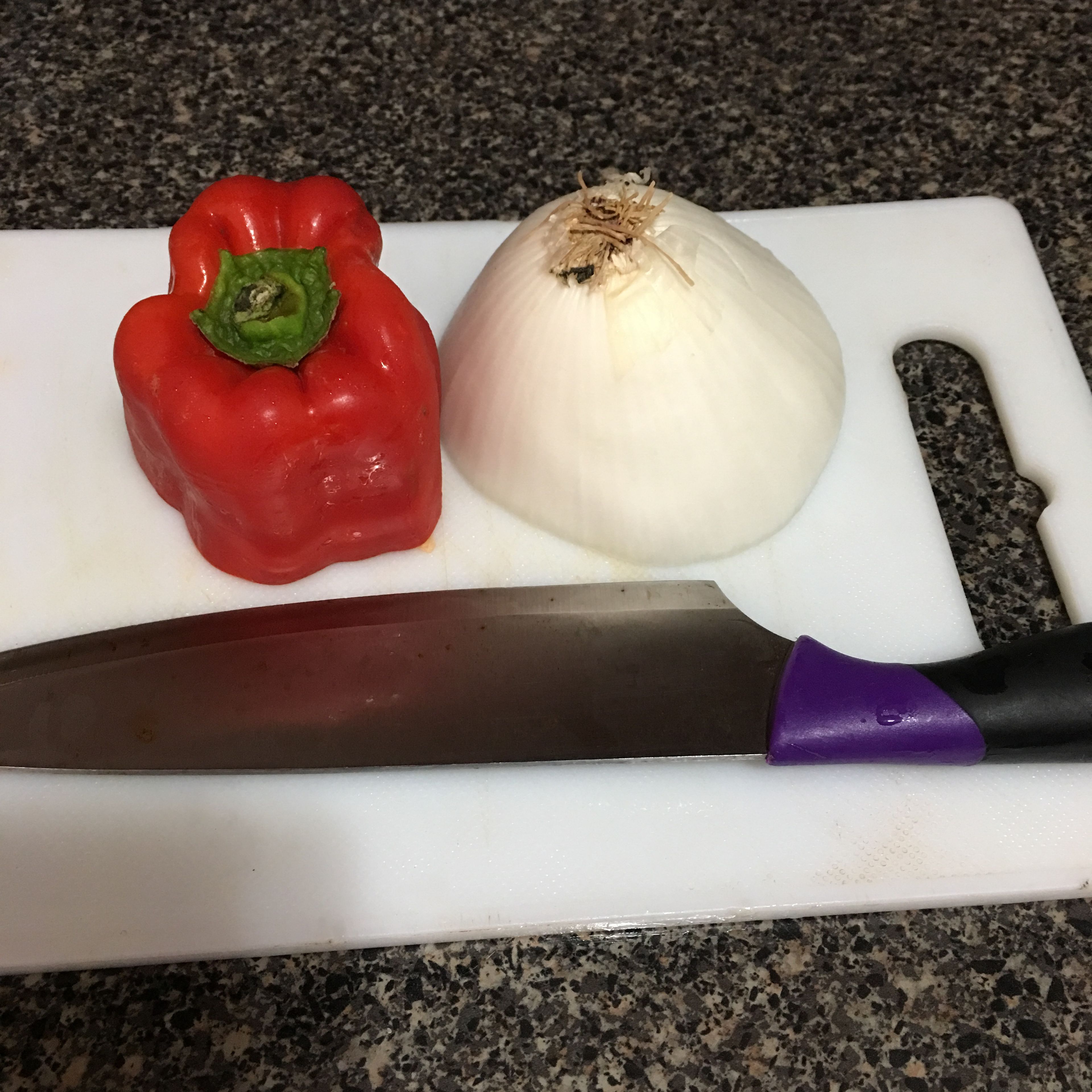 While the meat is resting and getting all of those flavors together, with a knife lets proceed to shop our white onion and our red bell pepper (you can use more than 1 color of bell pepper, I’m using the red one because of it sweet taste, and because it was the one I had on hand for this “under budget fajitas”