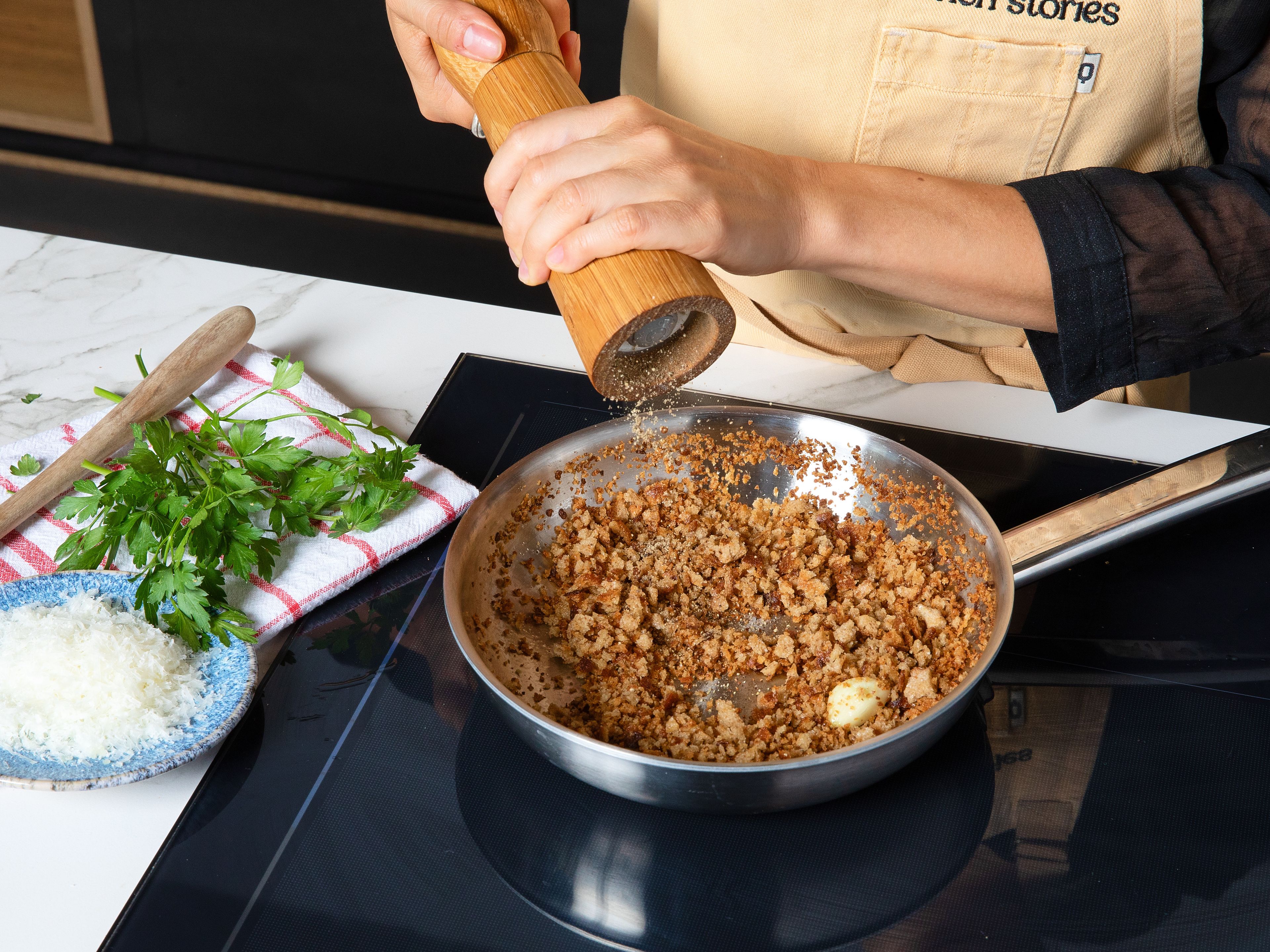 Bring a large pot of salted water to a boil and cook the pasta until al dente according to package instructions. For the pangrattato, finely crumble stale bread in a blender or use breadcrumbs. Heat the reserved garlic in a pan with olive oil. Add the breadcrumbs to the flavored oil and toast over medium heat until golden and crispy. Season with salt and pepper and, if desired, mix with chopped parsley and some grated cheese.