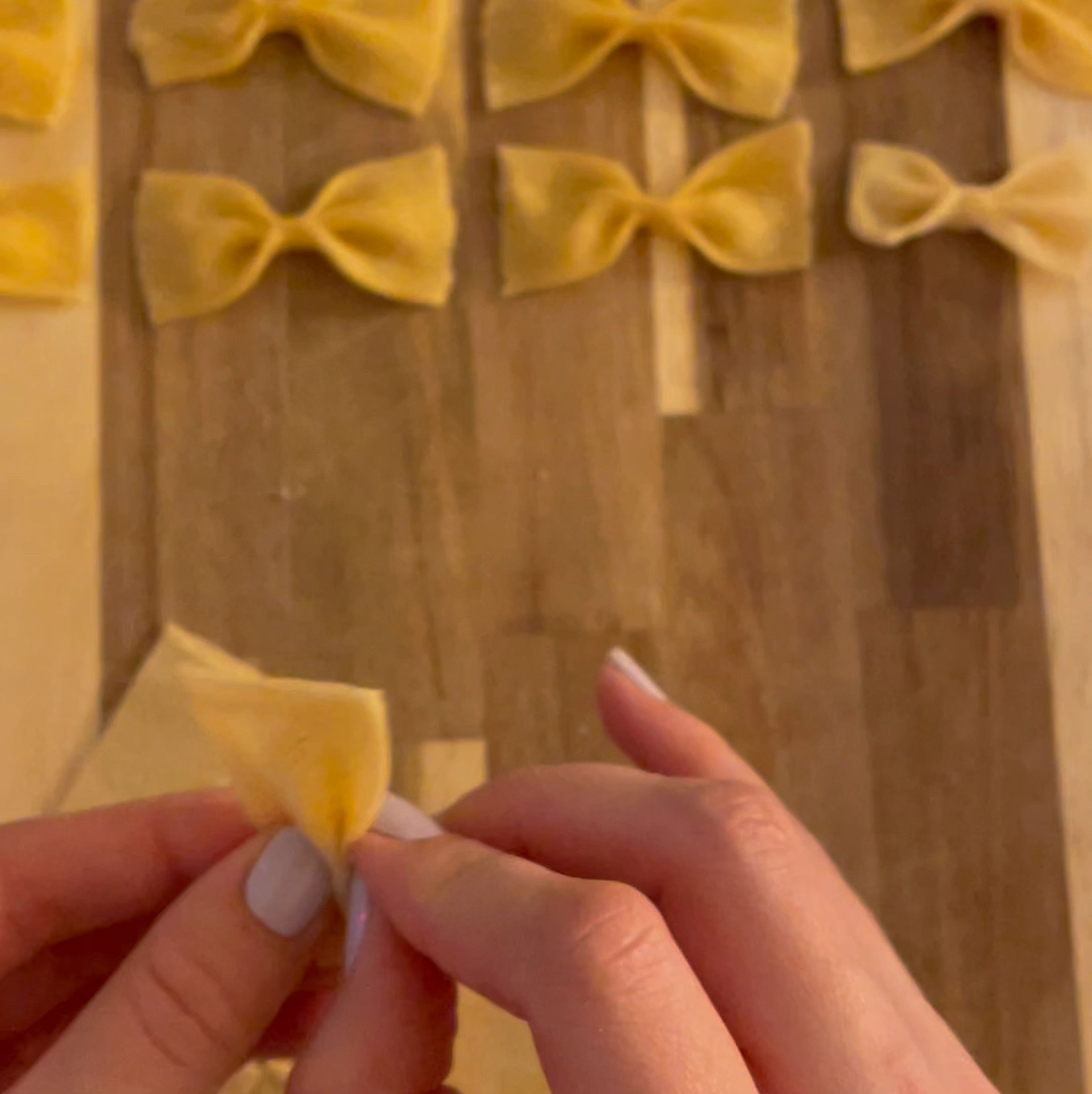 After resting dough for 1 hour, roll completely flat with dough roller or pasta maker and cut into tiny pieces. Fold the middle of the pieces together into Farfalle shapes.