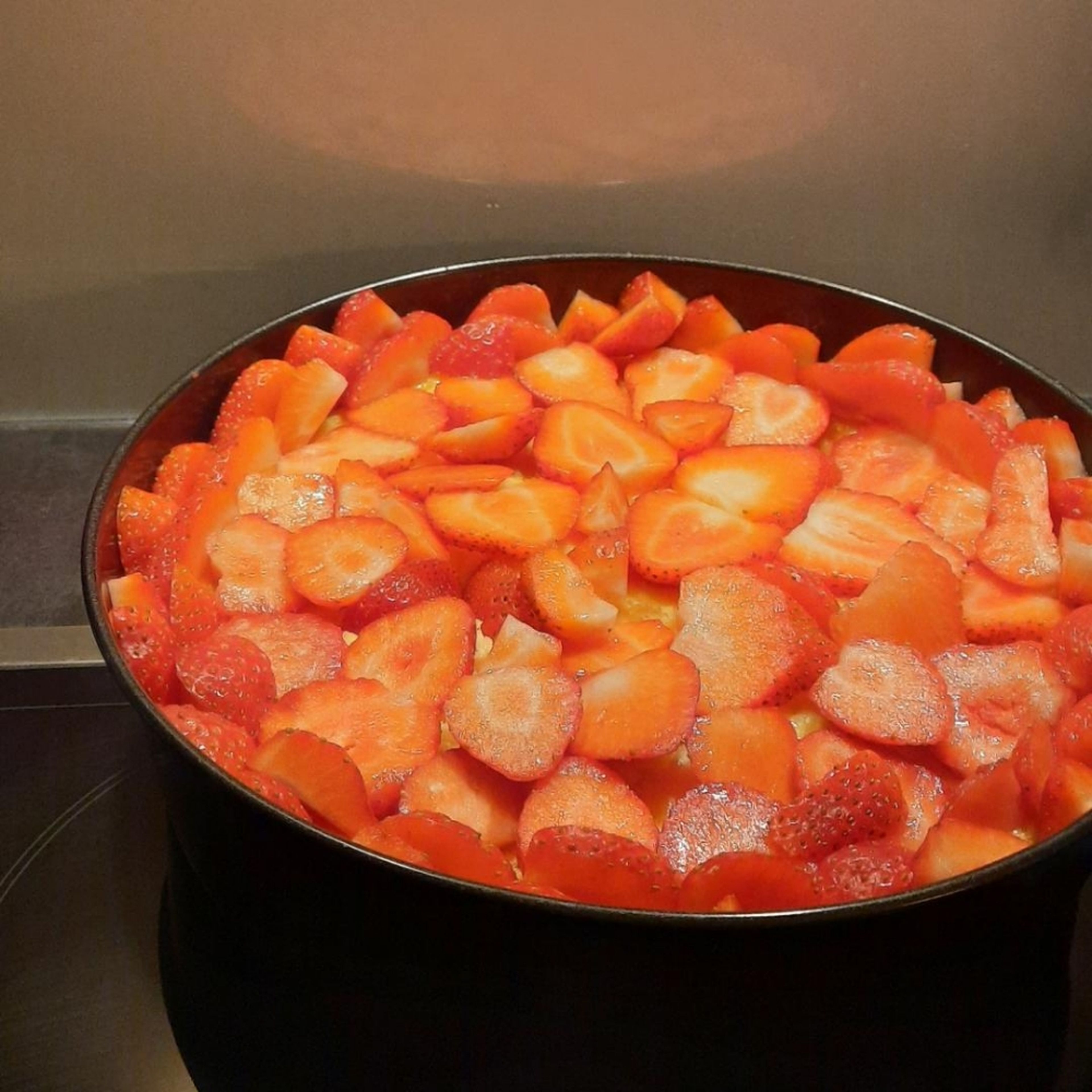 Die Erdbeeren waschen und in Scheiben schneiden. Sobald der Kuchen ausgekühlt ist die Erdbeeren darauf verteilen. Am Besten am Rand eine kleine Mauer mit den Erdbeeren auslegen, damit der Guss nicht zu sehr überlaufen kann.