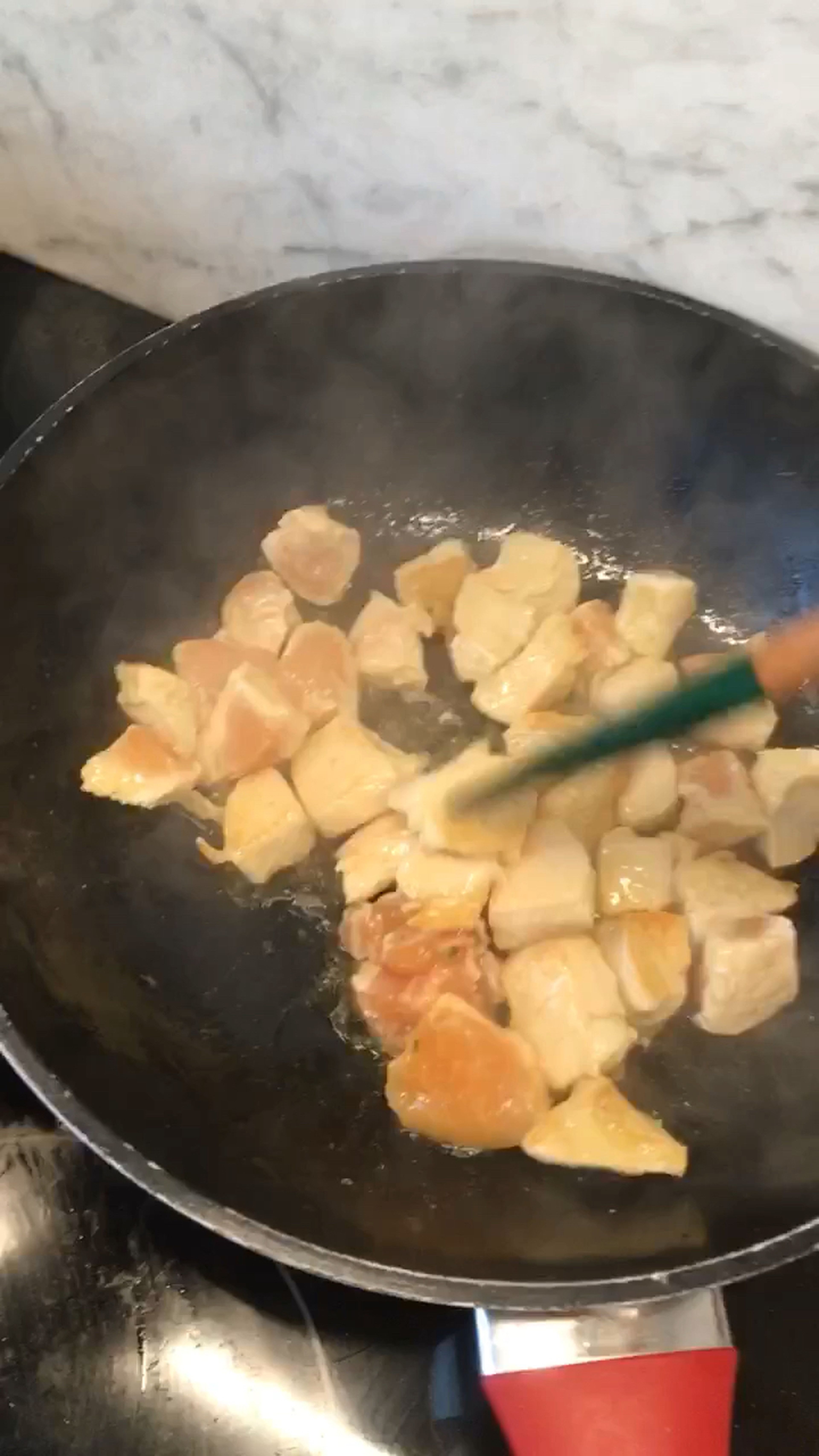 Put the remaining oil from the pan into a large wok and fry the chicken breasts on all sides.