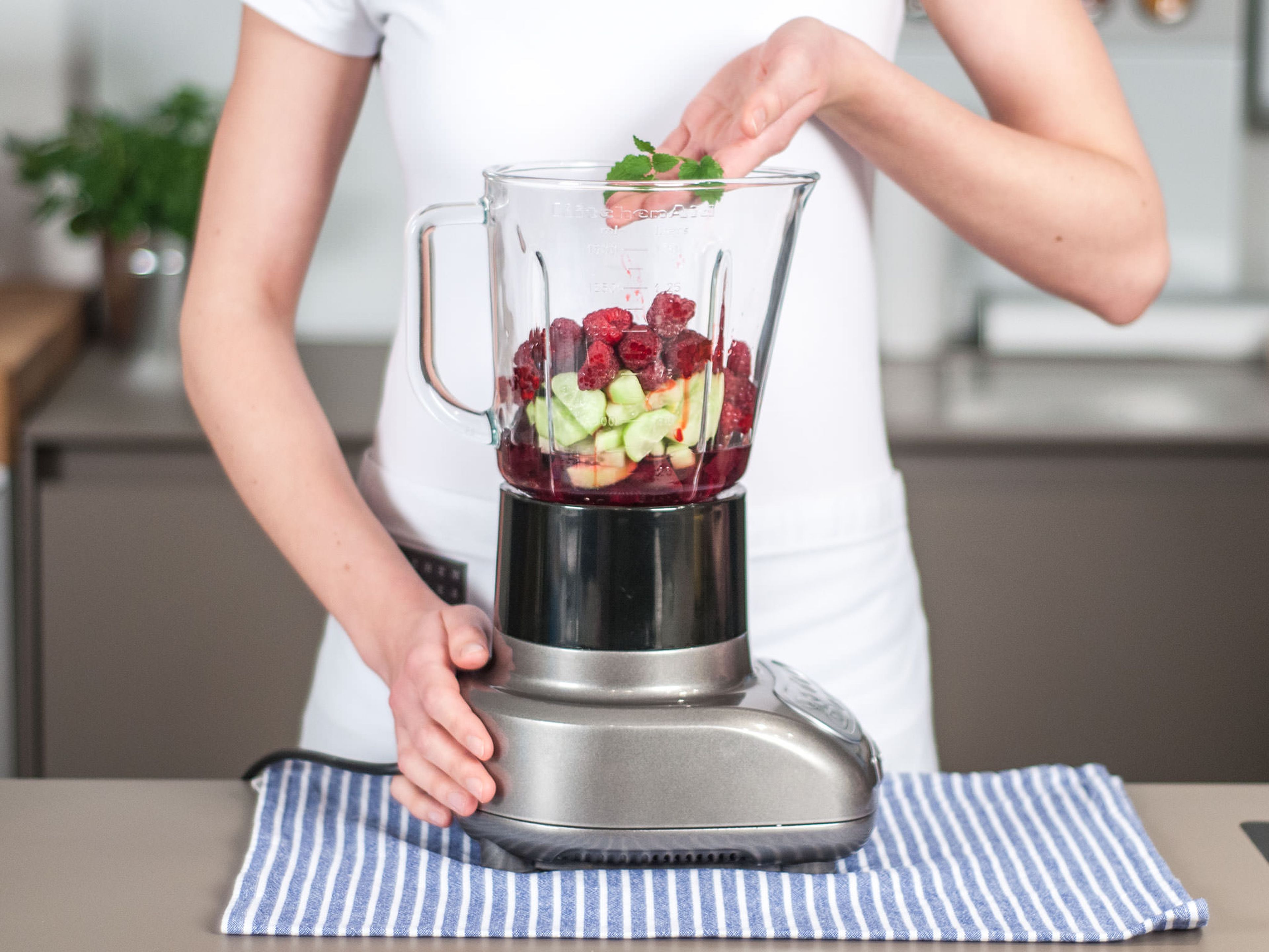 Place cucumber, red beets, frozen raspberries, agave syrup, and water into blender. Pick mint leaves and add to blender.