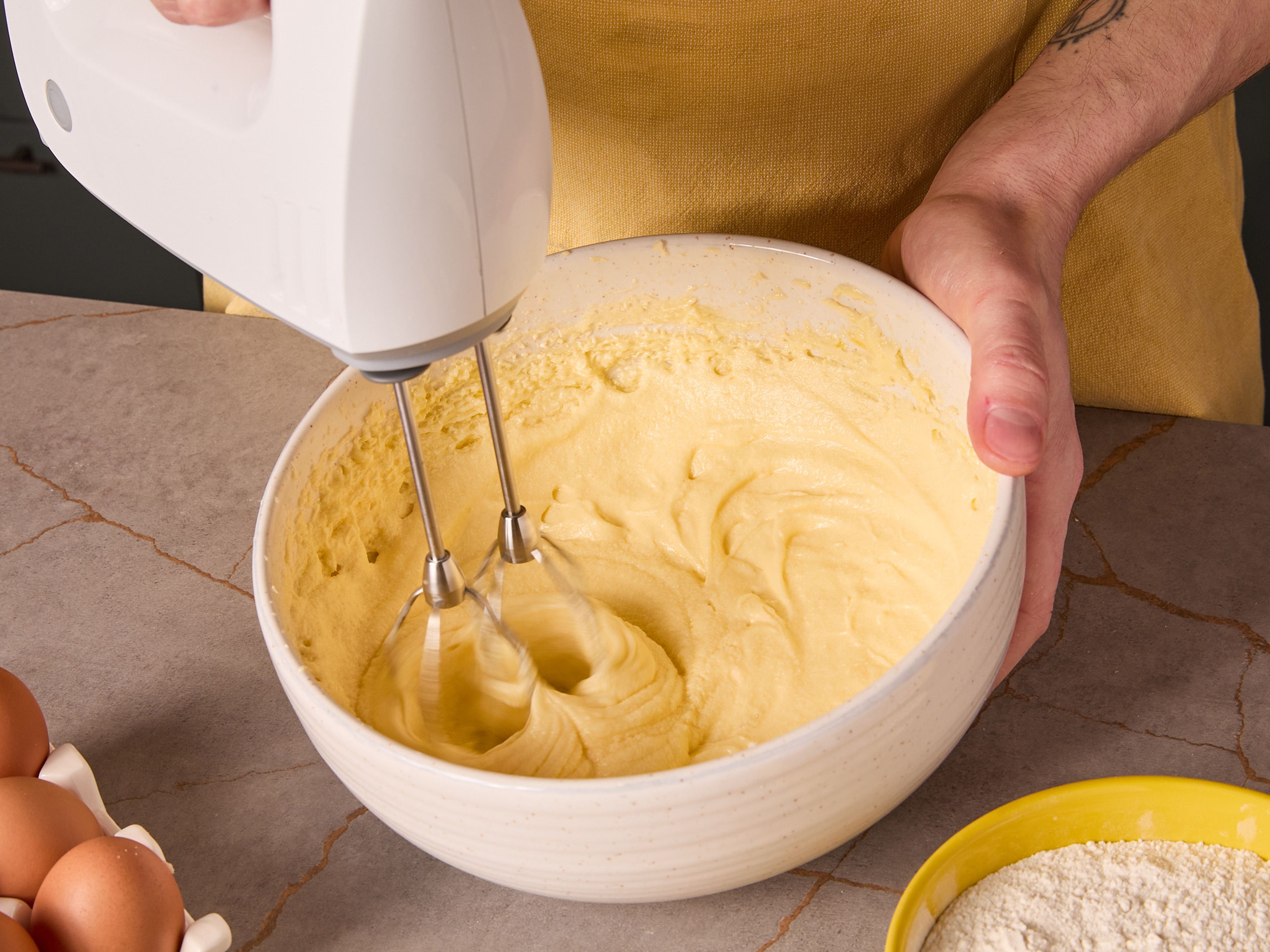 For apple cake, preheat the oven to 200°C/392°F (top and bottom heat). Beat butter and sugar until creamy with a mixer. Add eggs one by one, mixing well after each addition. Combine flour, baking powder, and ground almonds in another bowl. Then mix into the batter.