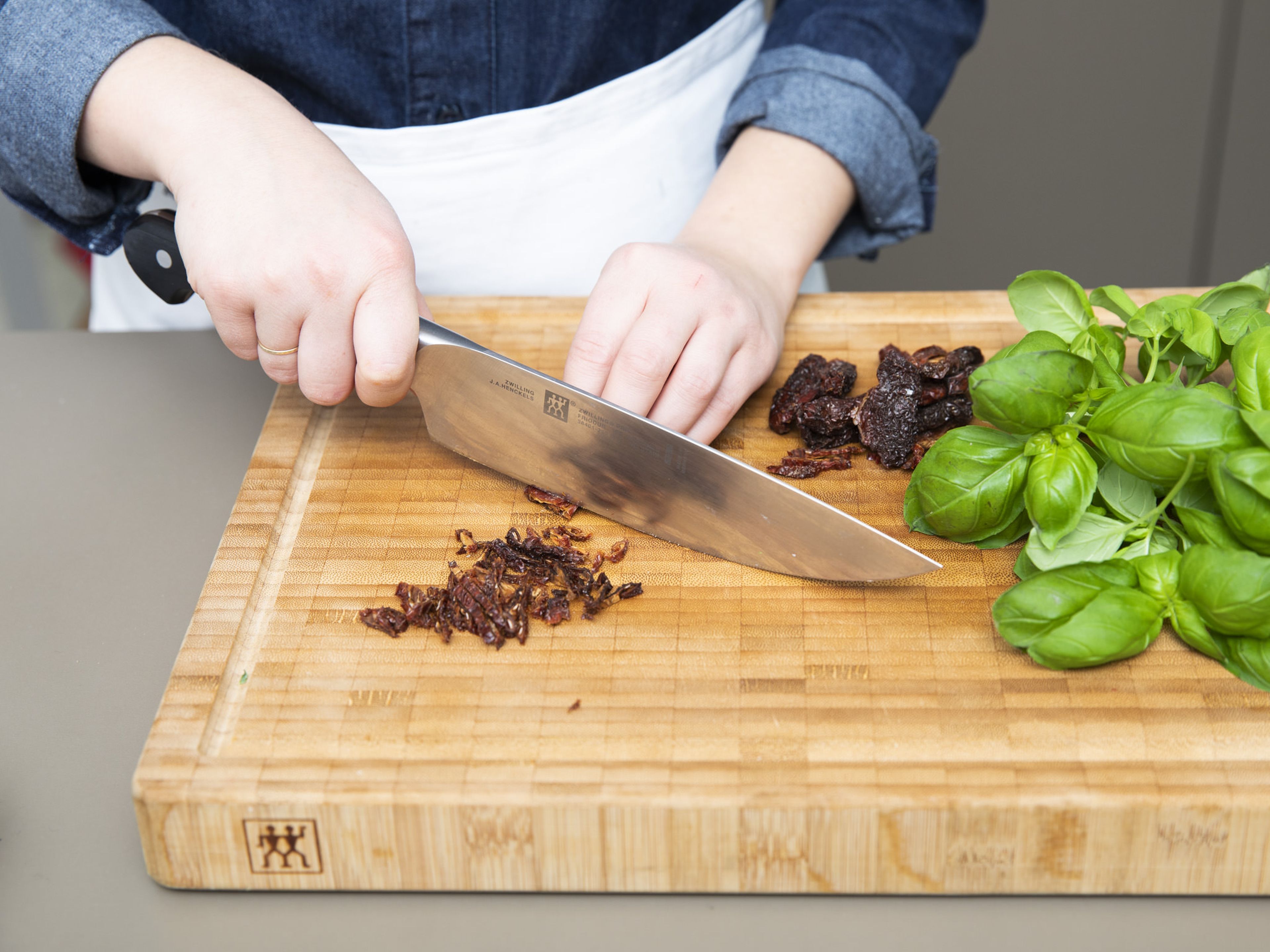 Finely chop the sun-dried tomatoes and basil. Add them to a bowl along with cooked risotto and mix well. Season with salt and pepper to taste. Spread the Risotto on a baking tray, roughly 1cm thick, cover with foil and chill in the fridge for approx. 30 min.