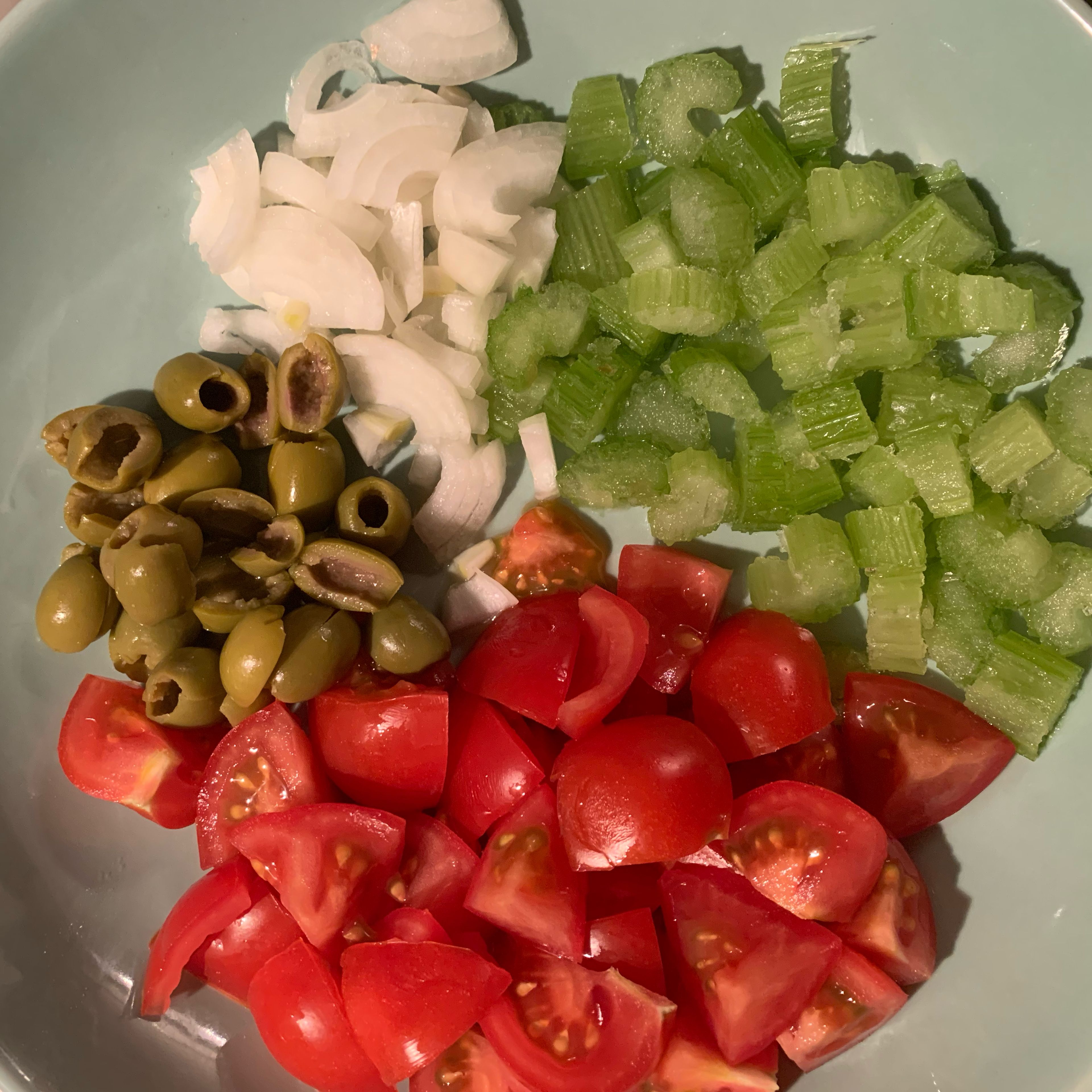 Cut the onion, tomatoes, celery and olives.