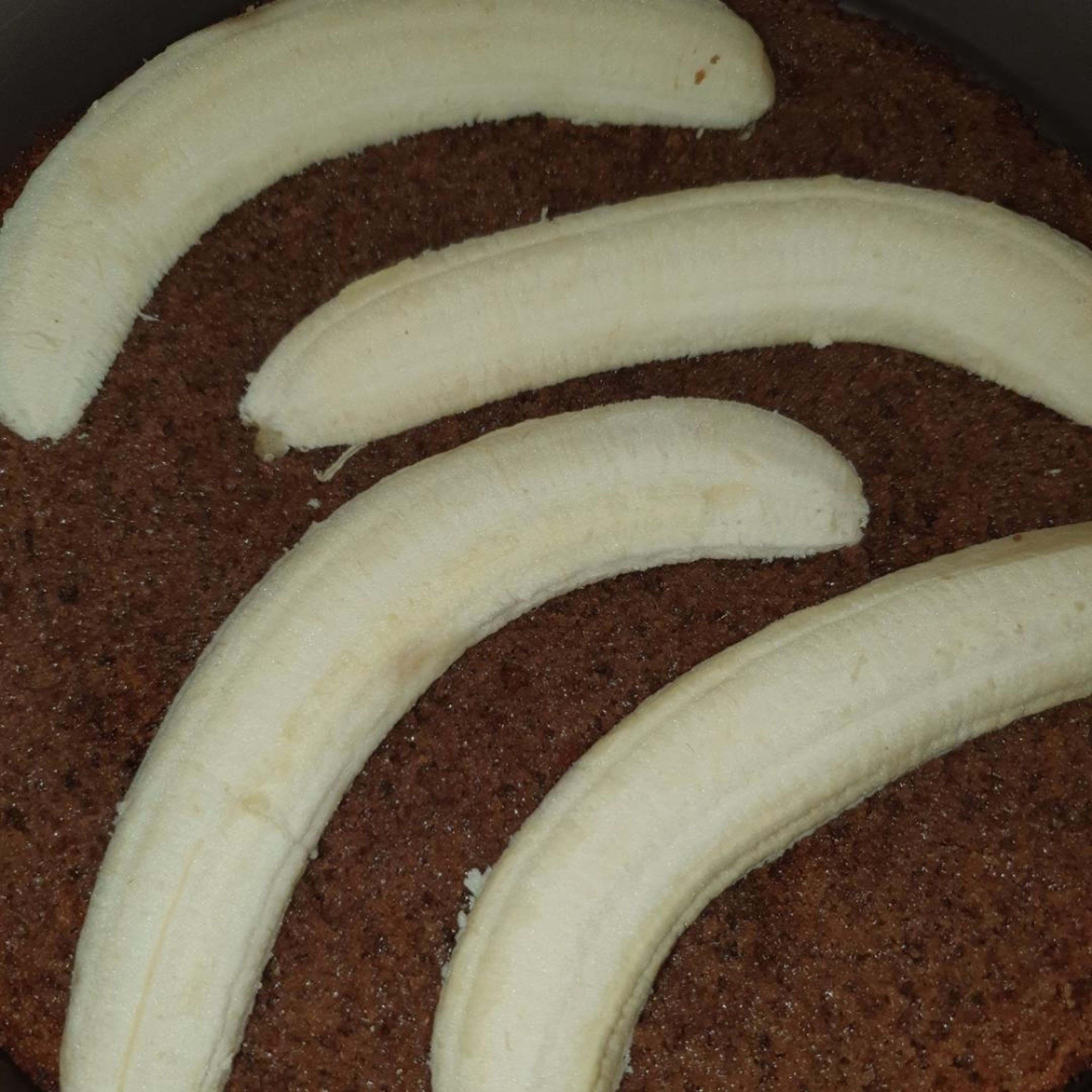 Bananen schälen, der Länge nach halbieren und auf dem unteren Boden verteilen. Springform als Rand aufsetzen und die geschlagene Sahne auf den Bananen verteilen. Mit dem zweiten Boden zudecken und zum Kühlen in den Kühlschrank stellen.