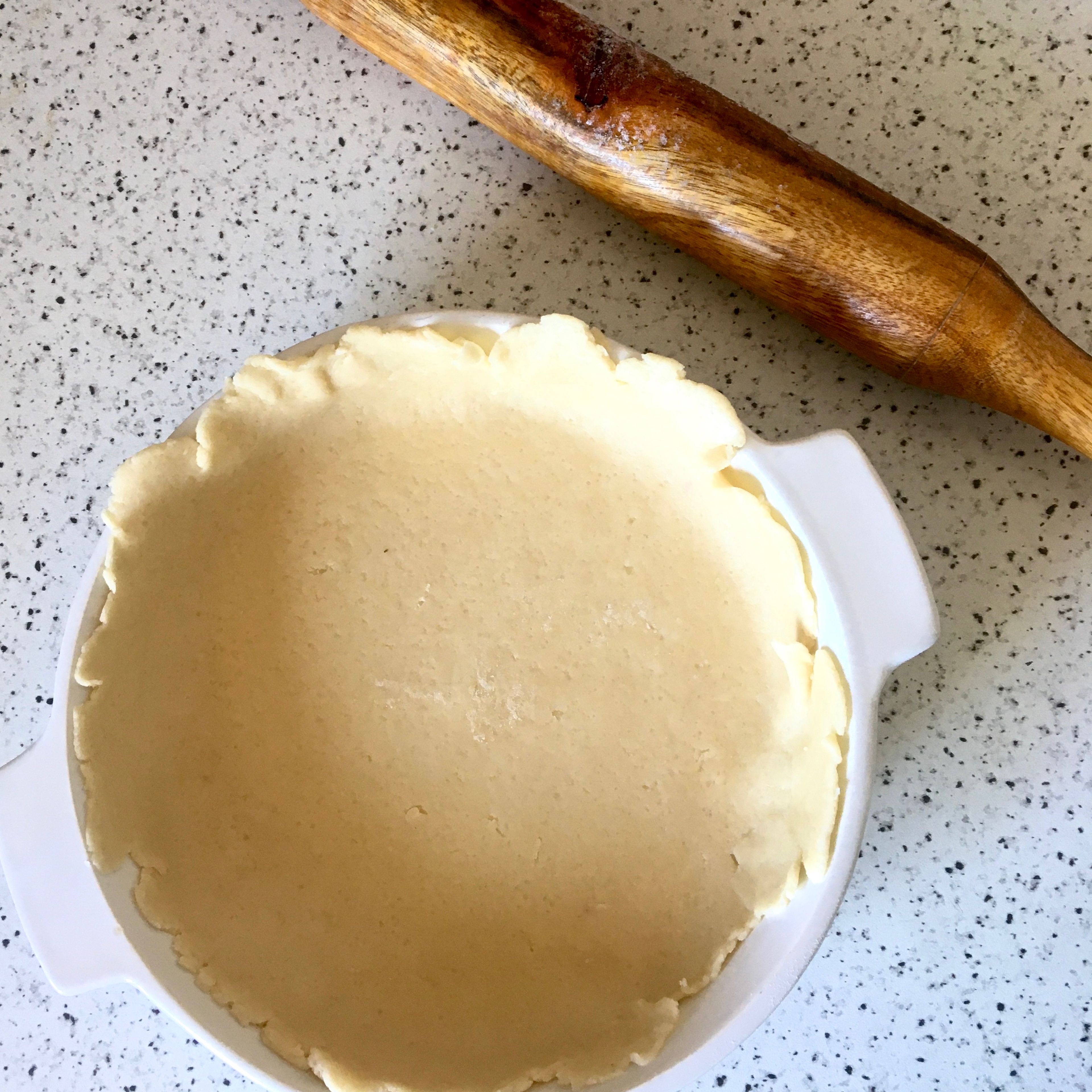 Divide the dough in two unequal pieces, around 40%-60% is a good division. Flour a rolling pin and work surface. Roll out the bigger piece of dough into a disc, slightly larger than your pie dish. Transfer it to the dish, covering the bottom and sides. Sprinkle the cinnamon over the base.