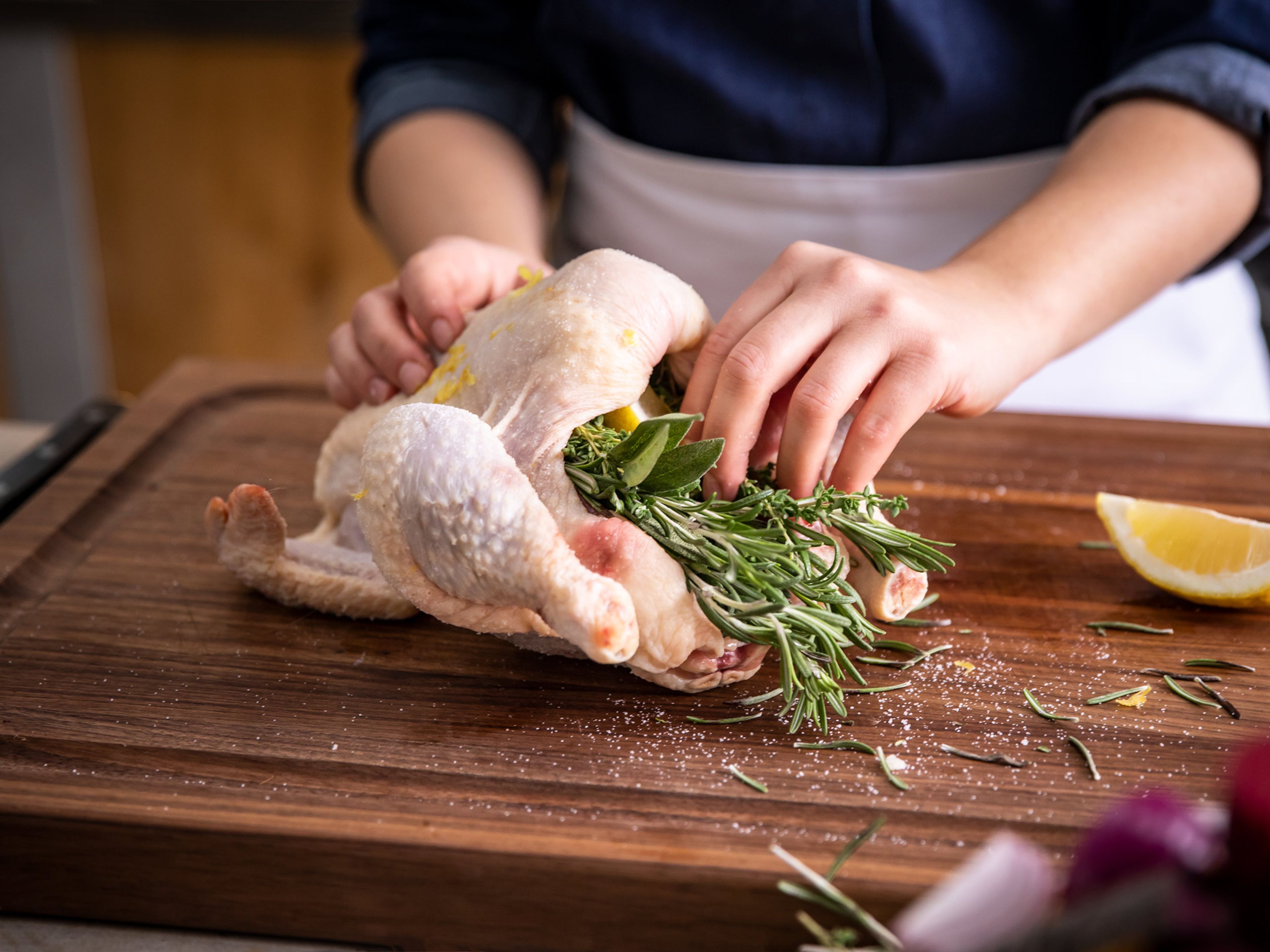 Season the chicken all over with flaky sea salt, rubbing it into the skin. Zest half the lemon and rub into the chicken skin. Quarter the lemon and stuff into the chicken cavity along with thyme, rosemary, and sage.