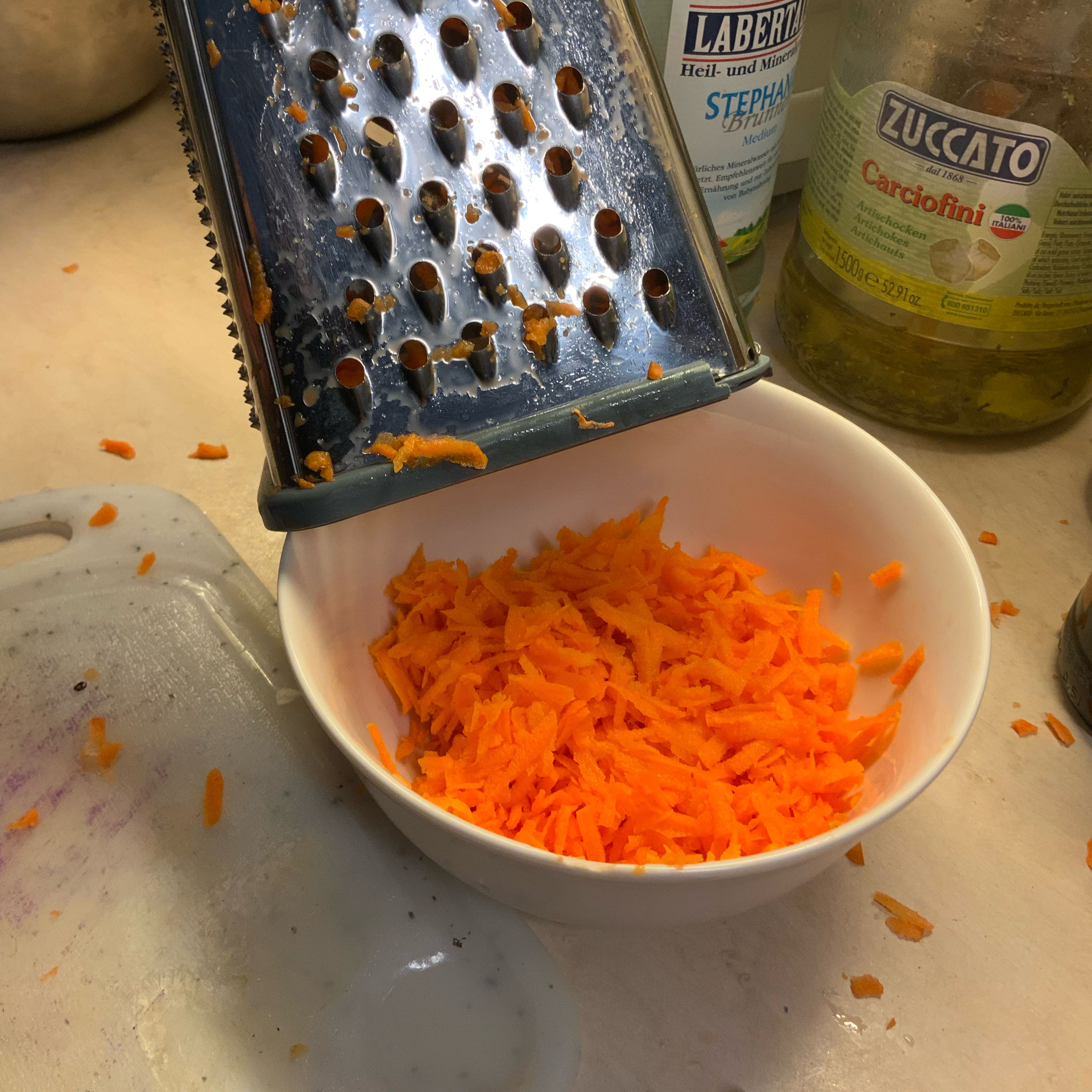 Karotten schälen und mit einer Küchenhobel mittelfein raspeln.
