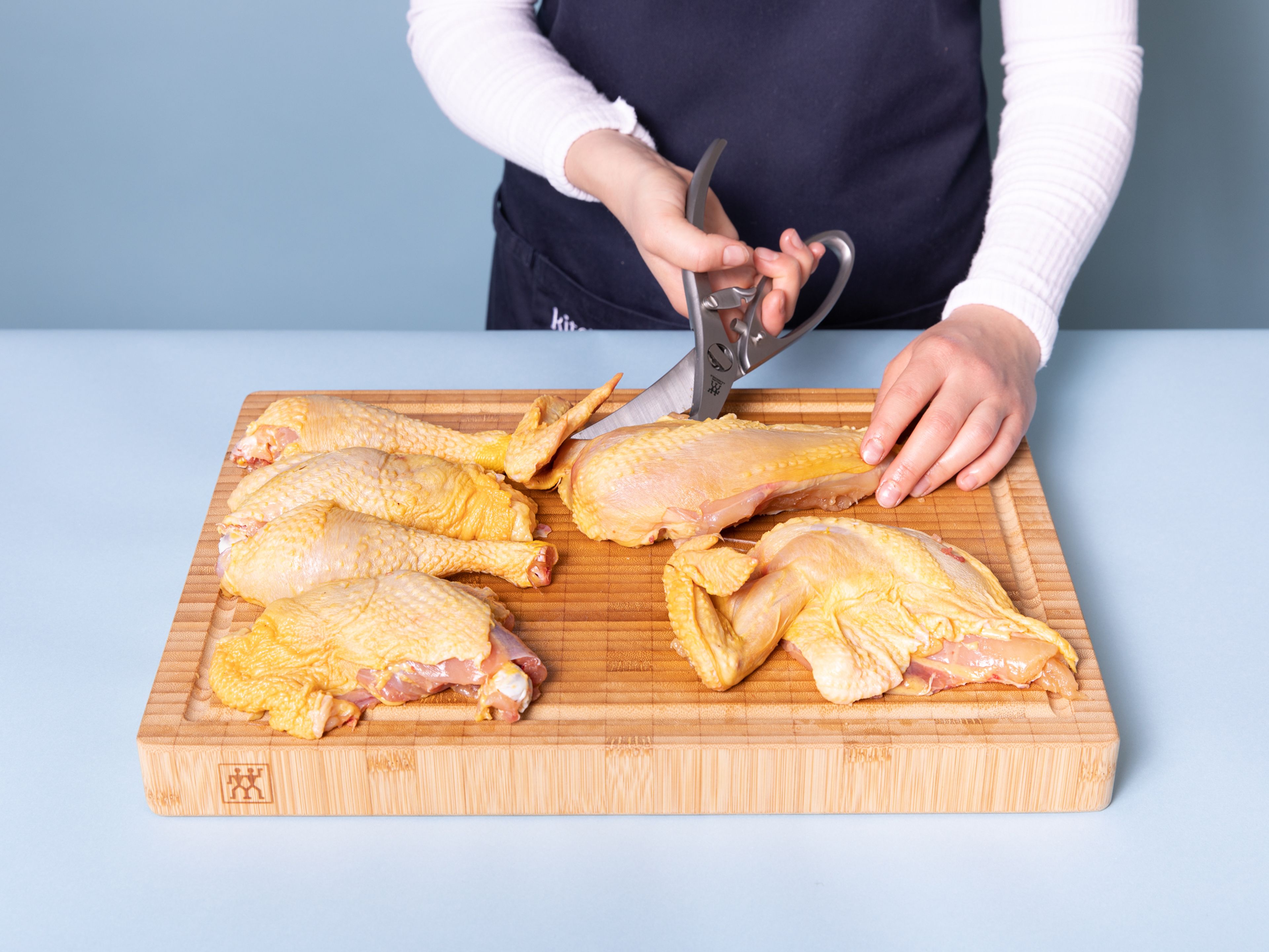 Den Ofen auf auf 200°C vorheizen. Das Huhn mit einer Geflügelschere zerteilen. Hierfür zuerst auf beiden Seiten der Wirbelsäule und dann durch das Brustbein schneiden. Nun die Brust und Beine trennen, dann die Unterschenkel und Schenkel sowie Brust und Flügel. Von allen Seiten gut Salzen und beiseite stellen.