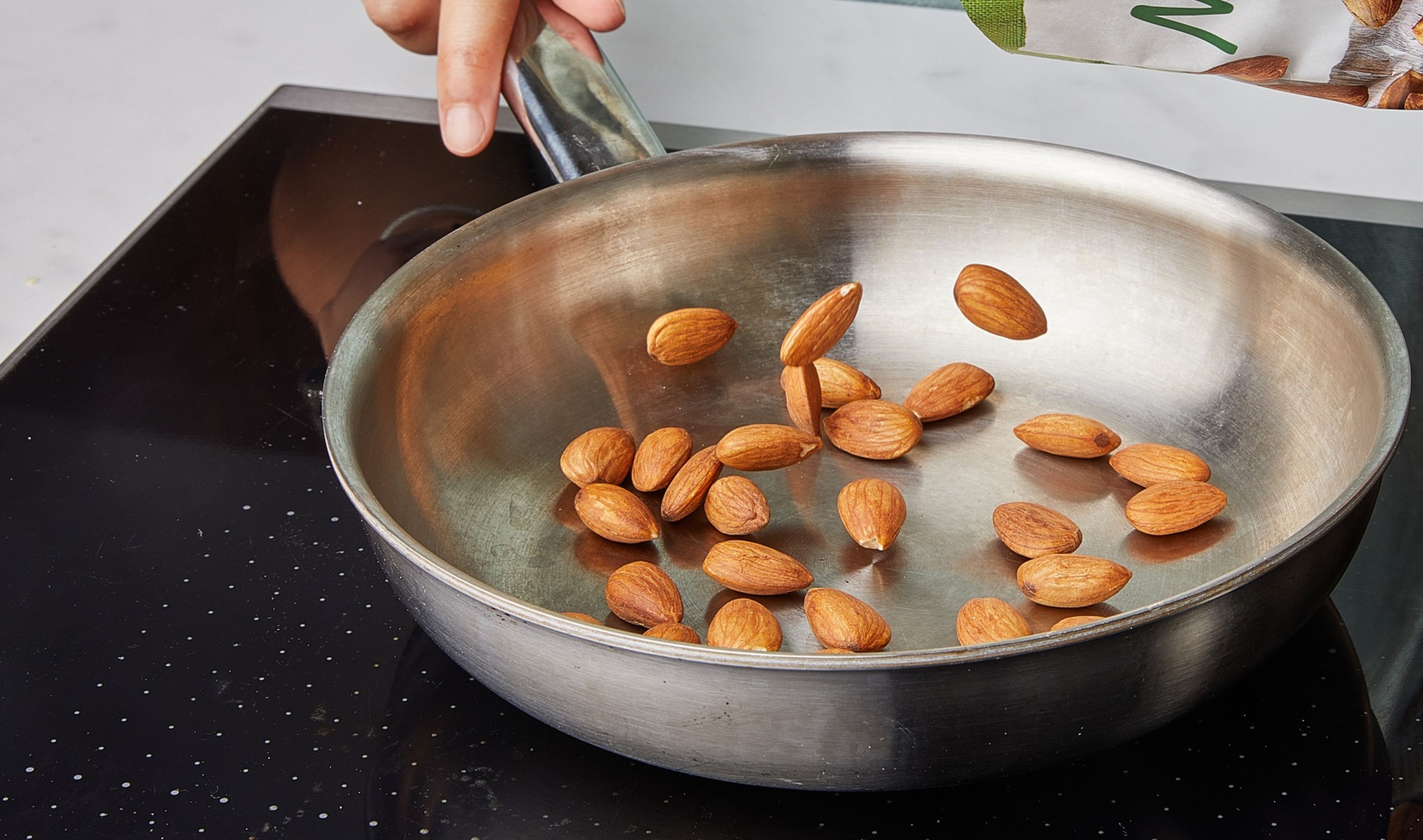 Die Mandeln in einer Pfanne trocken rösten, bis sie goldbraun sind. Herausnehmen, abkühlen lassen und grob hacken. Die Hälfte der Mandeln für die Gremolata beiseite stellen.