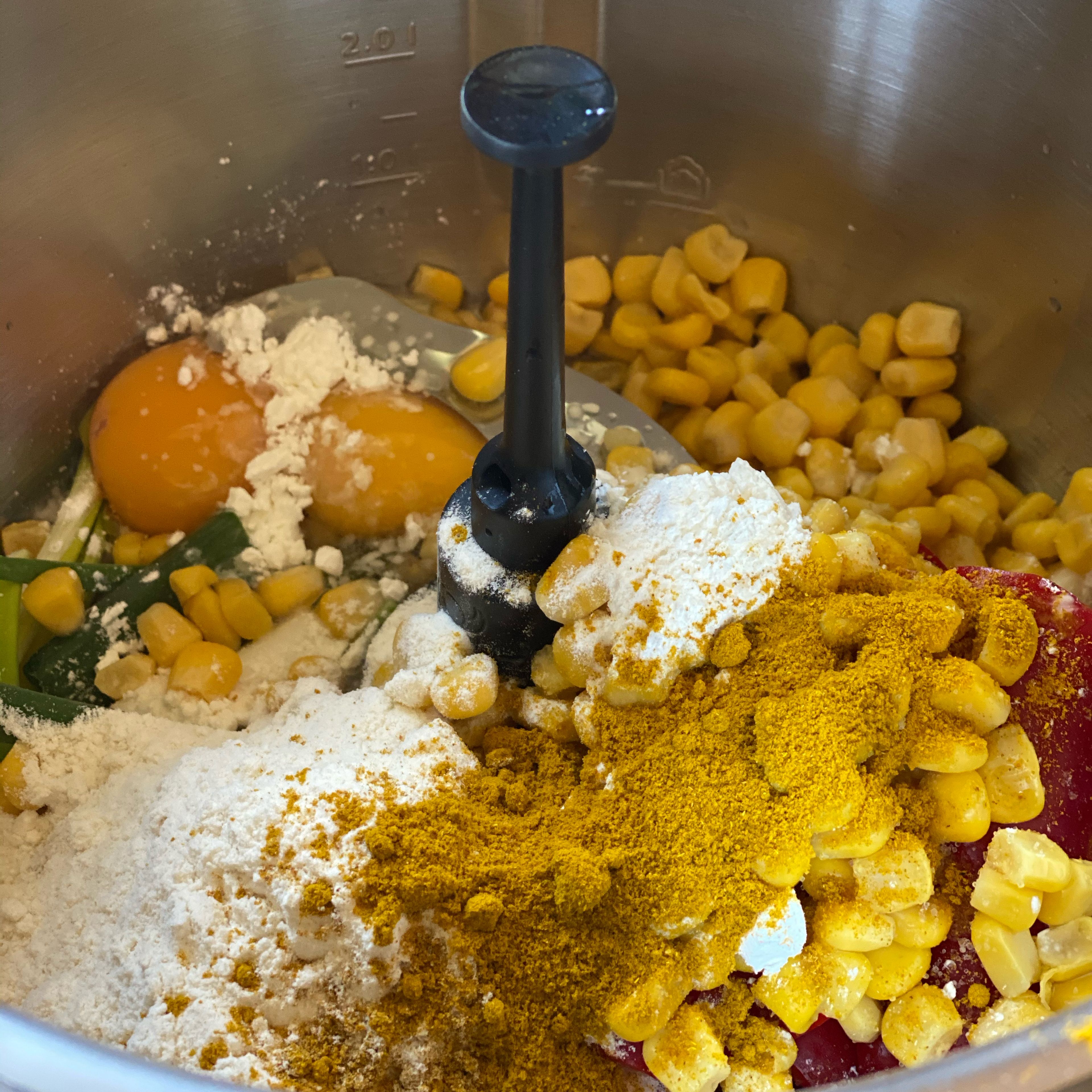 Den Bosch Cookit reinigen, Programm Manuelles Kochen anwählen, Cookit Universalmesser einsetzen, Frühlingszwiebel, Paprika in Stücke, Mais aus der Dose, Currypulver, Salz, 1 TL Speisestärke, 50g Mehl, 2 Eier zufügen, Programm I Stufe 10 I 20 Sek. laufen lassen