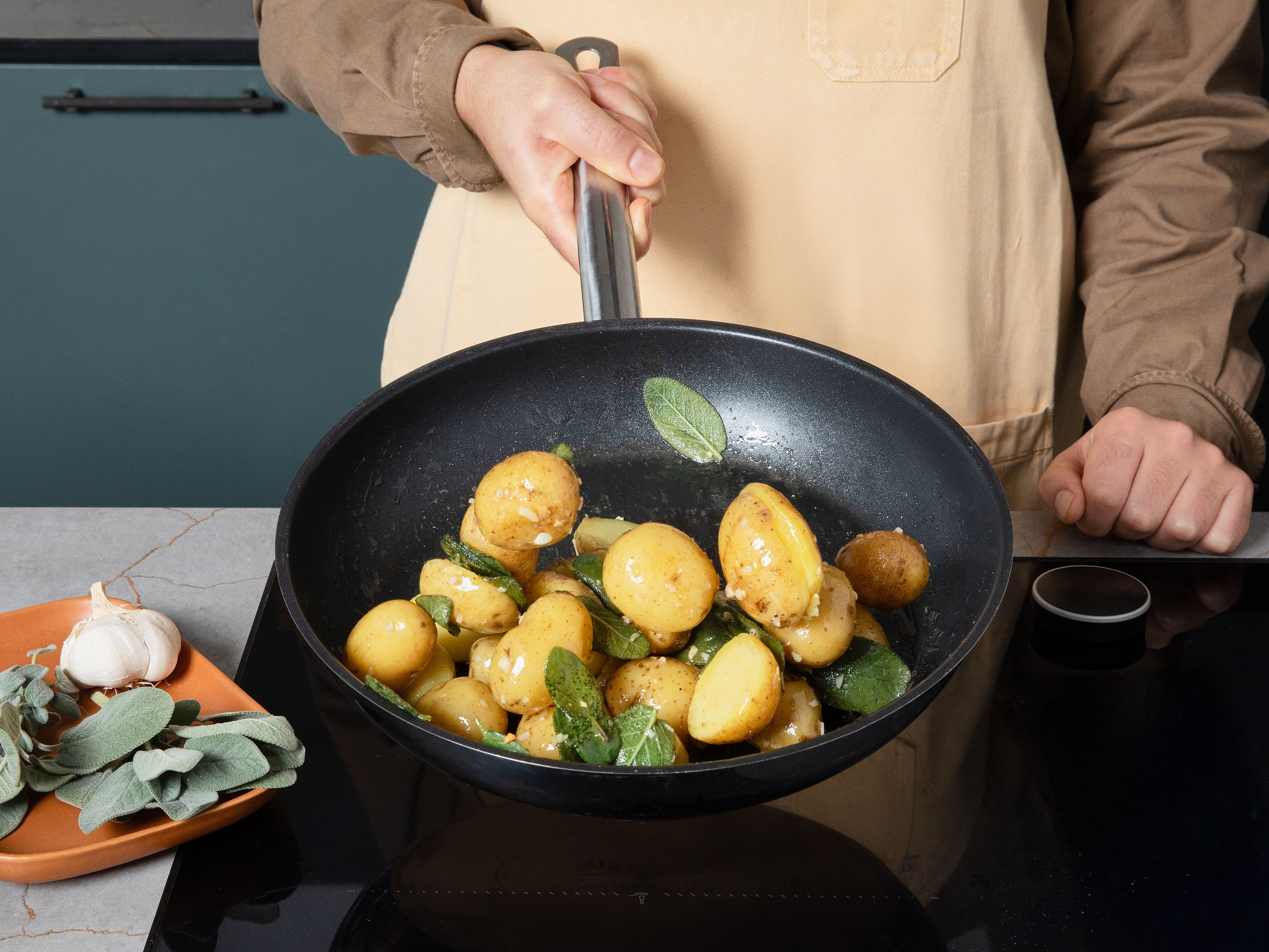 Während das Gulasch schmort, die Kartoffeln je nach Größe halbieren. In einem großen Topf mit kaltem Wasser aufsetzen, aufkochen, salzen und ca. 15 Min. köcheln lassen, bis sie weich sind. Abgießen und beiseitestellen. In einer Pfanne einen Teil der Butter schmelzen. Den restlichen Knoblauch zusammen mit den Salbeiblättern bei mittlerer Hitze ca. 5–10 Min. in der Butter aromatisieren, bis sie leicht gebräunt ist. Kartoffeln zugeben, schwenken und mit Salz und Pfeffer abschmecken. Warm halten.