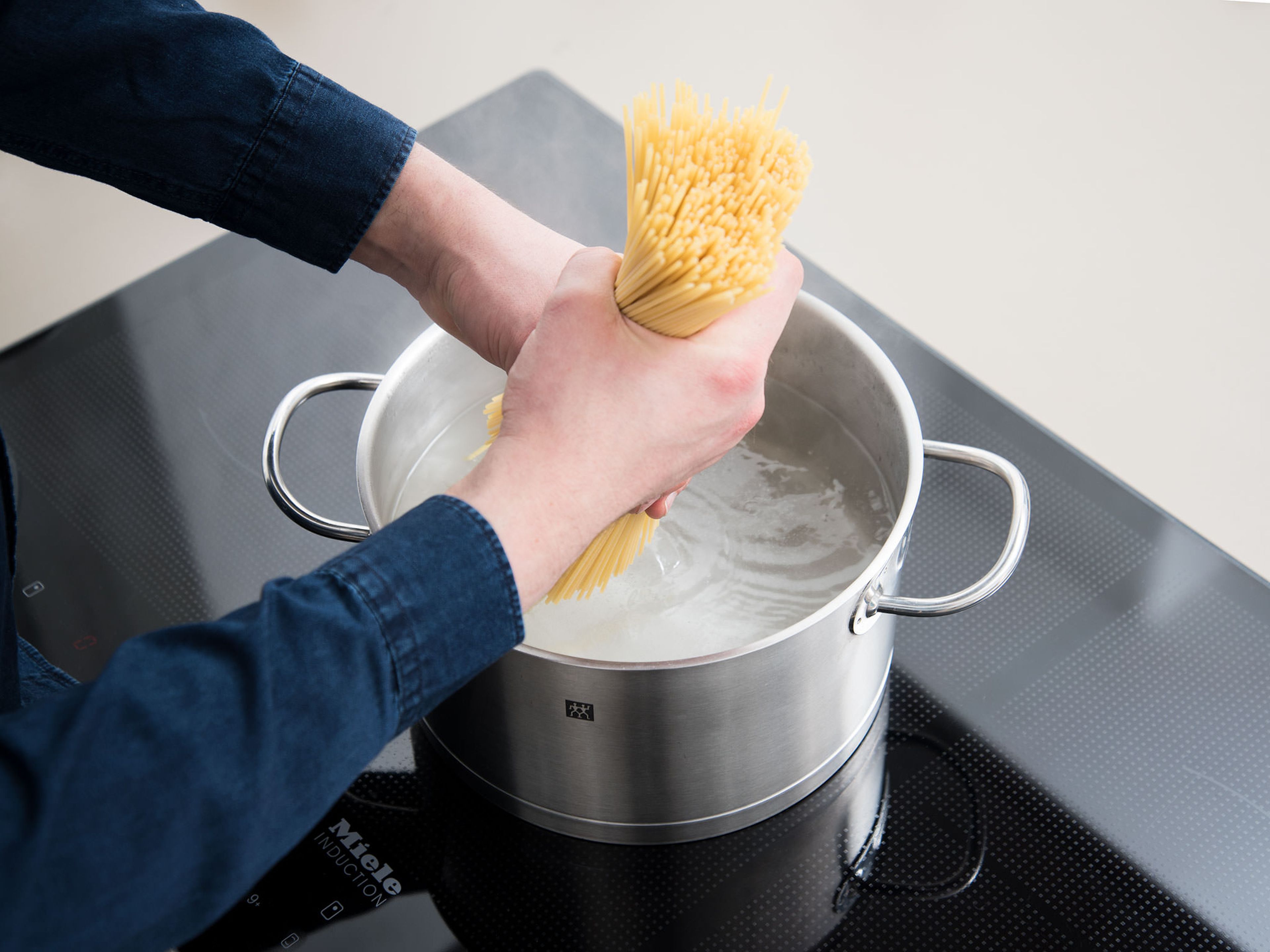 Spaghetti nach Packungsanweisung al dente kochen und in einem Küchensieb abgießen.