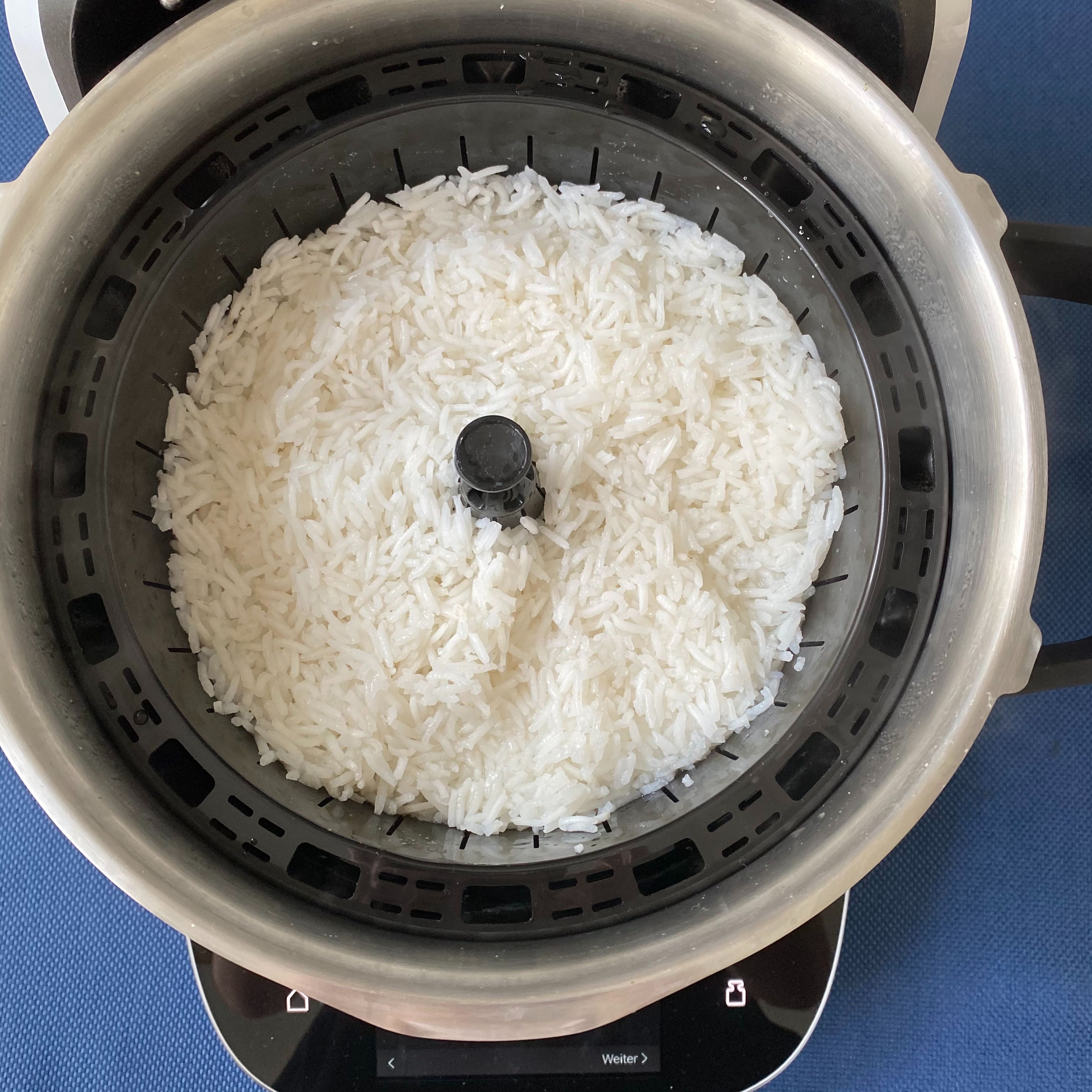 Den Reis mit dem Automatikprogramm „Reis kochen“ im Gareinsatz kochen, dabei die Kochzeit der Packungsanleitung anpassen. Den Reis umfüllen und warmhalten. Das Wasser ausschütten und Topf trocken wischen.