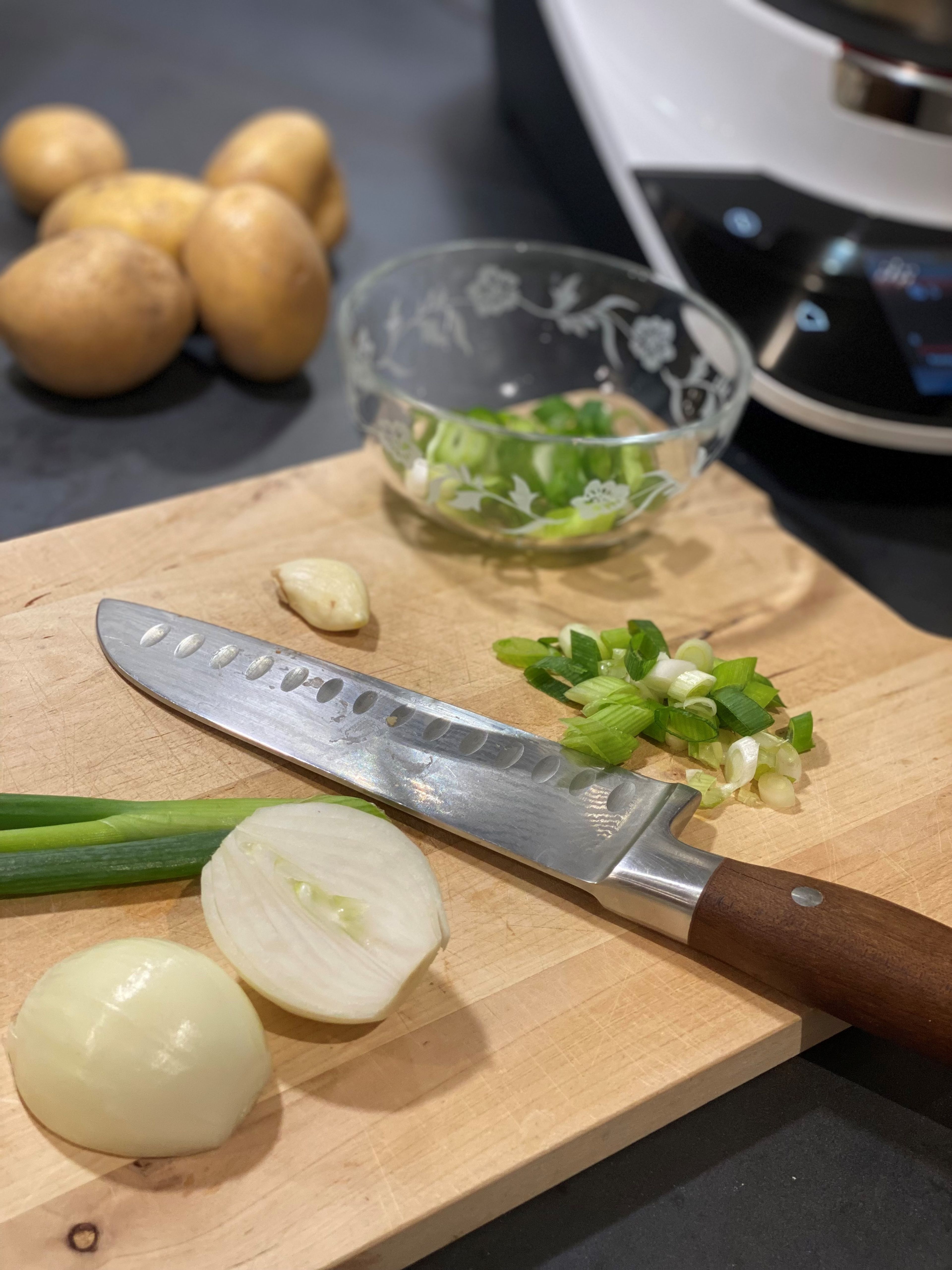 Als nächstes die Zwiebel schälen und halbieren. Die Frühlingszwiebeln in Ringe schneiden und zur Seite legen. Den Knoblauch fein hacken.