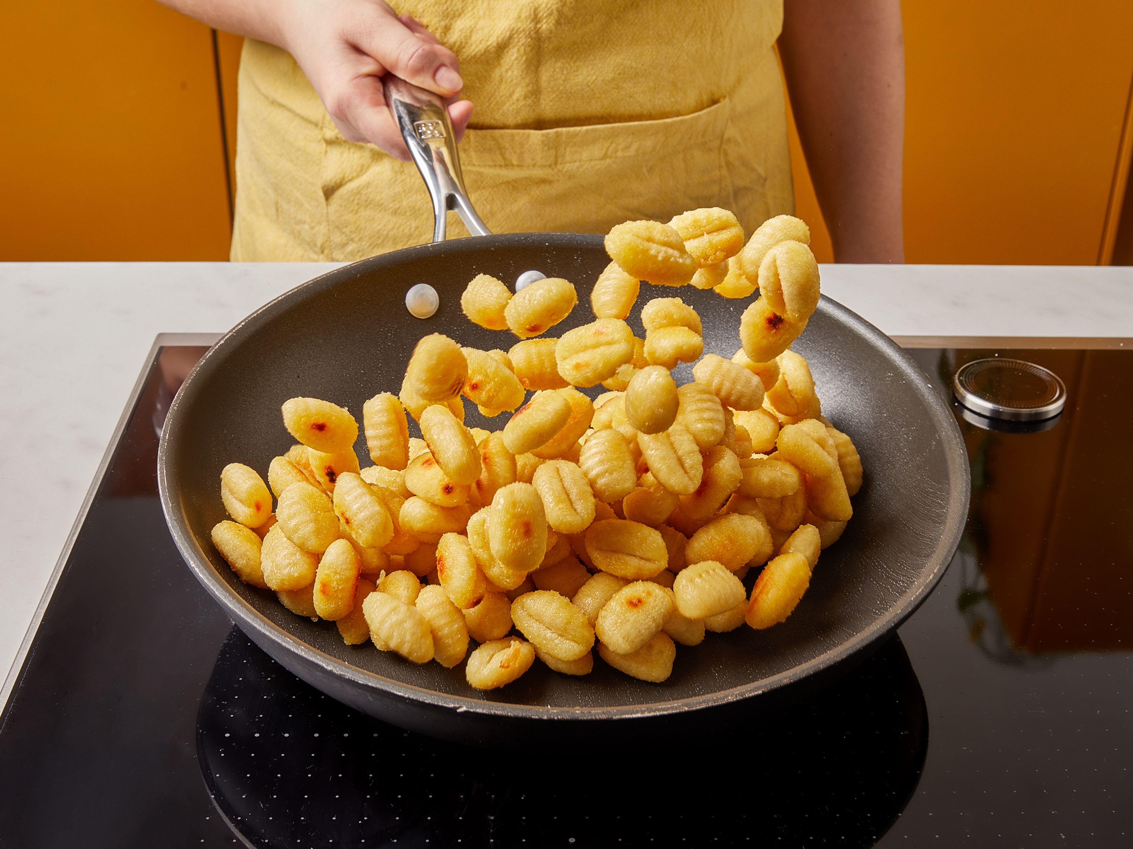 Preheat oven to 200°C/400°F. Pluck basil leaves from stems. Remove the casings from the sausage and discard, then roughly chop sausage. In a frying pan, add some oil and sauté the gnocchi until golden brown on both sides.