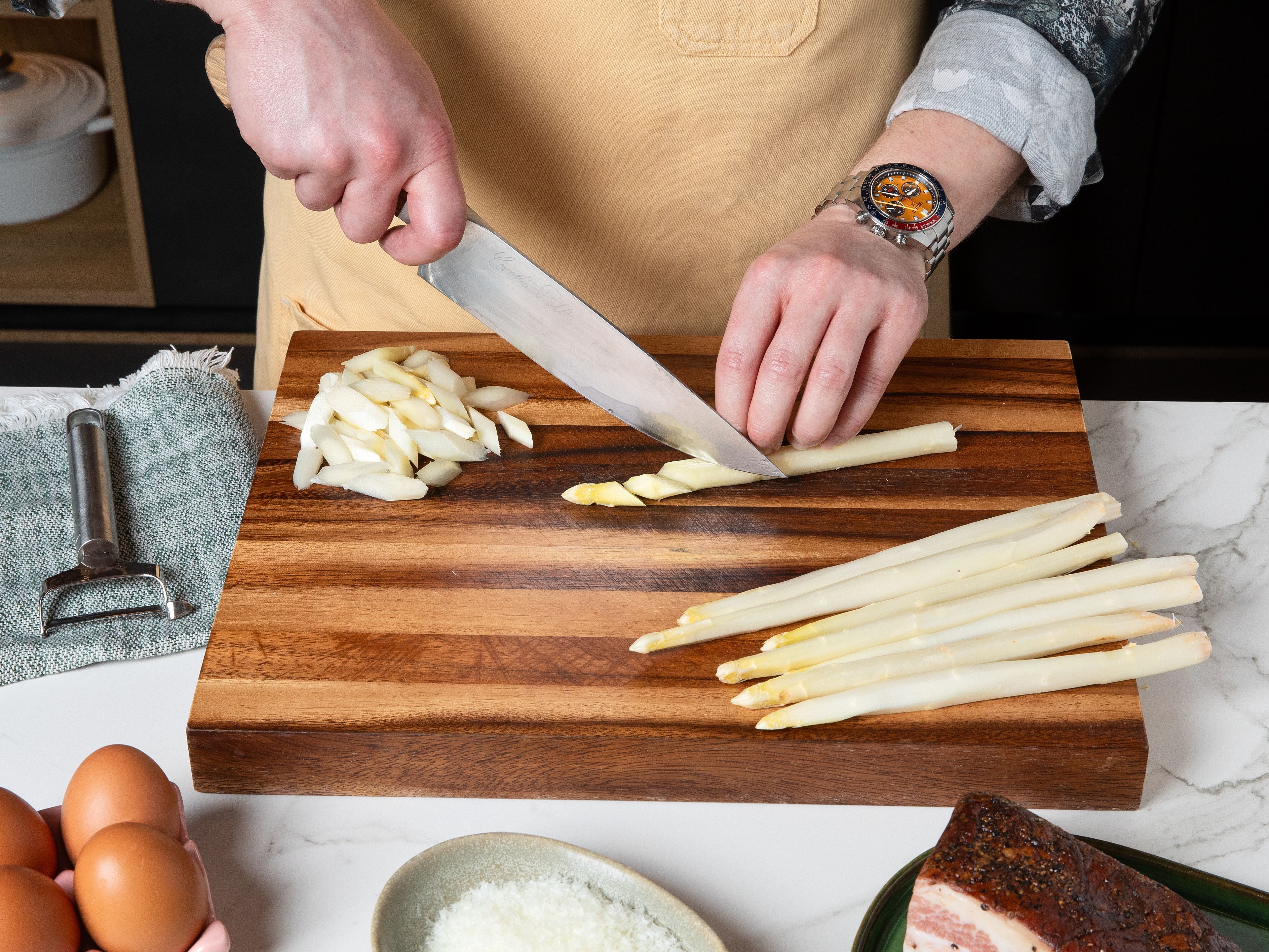First, bring a pot of salted water to boil for the spaghetti. In the meantime, chop guanciale into approx. 1 cm/0.3 in. cubes. Then trim the ends, peel and chop white asparagus into approx. 1 cm/0,3 in. thick medallions. Next, in a large bowl, whisk together egg yolks and Pecorino until a thick paste forms, and season with a pinch of salt and a generous amount of pepper.