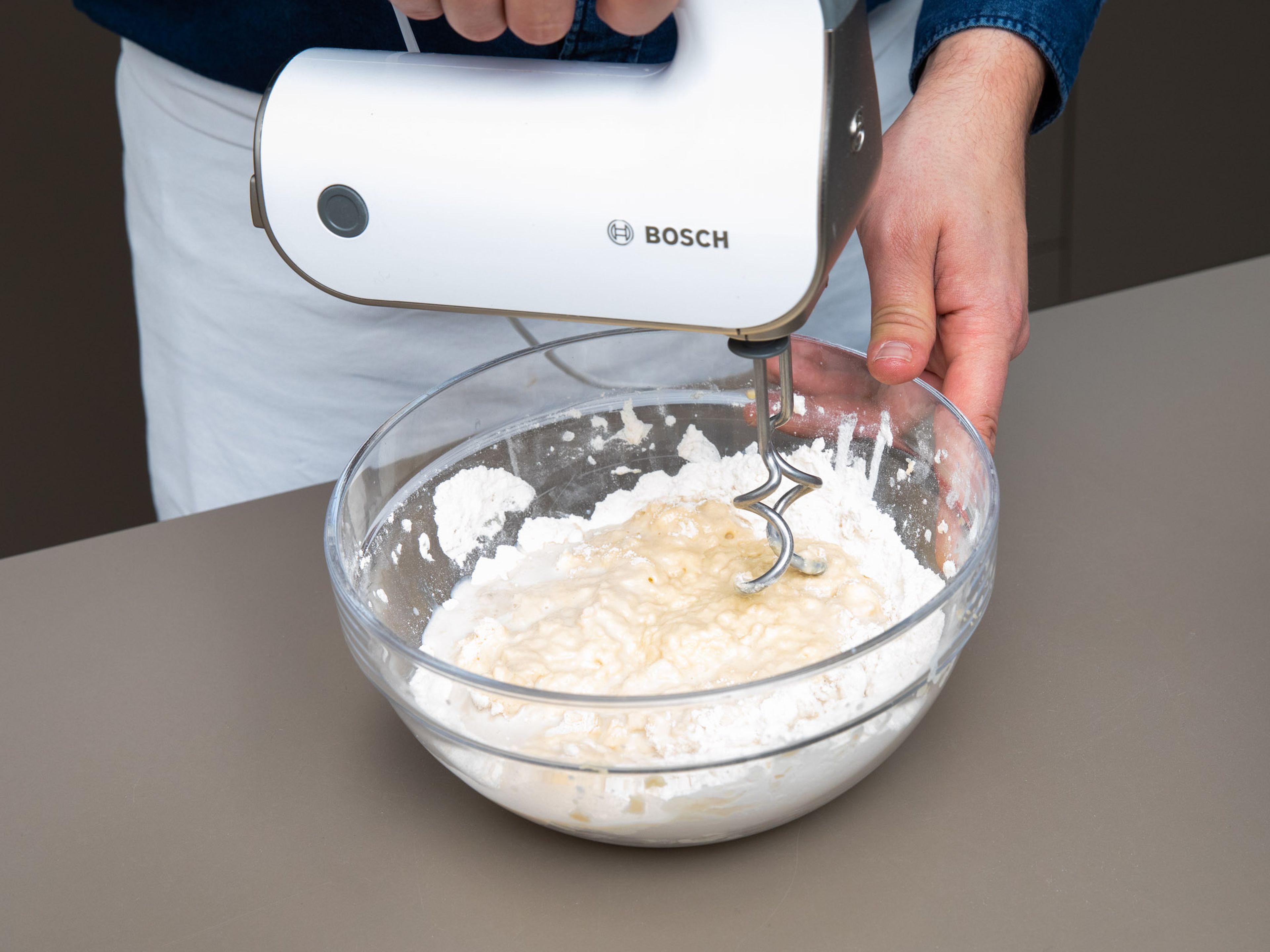 Add flour, remaining sugar, salt, some of the softened butter, and eggs to a large bowl and mix with a hand mixer with dough hooks until combined. Add yeast-milk mixture little by little until a smooth dough forms.