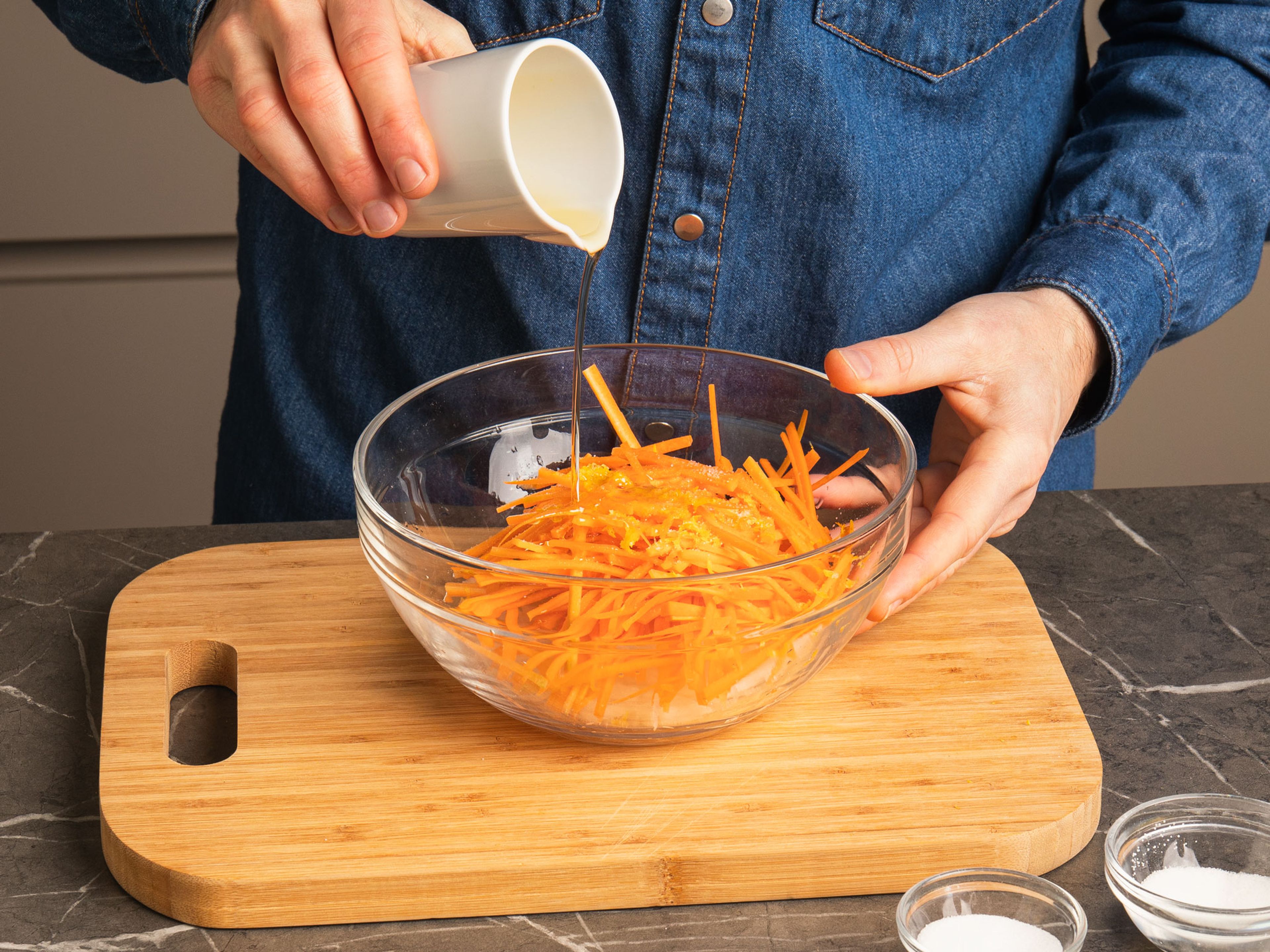 Karotten und Rettich schälen und in 8cm lange feine Streifen schneiden oder hobeln. Anschließend mit Salz, Zucker, Zitronensaft und Abrieb, sowie Sesamöl vermengen und ziehen lassen.