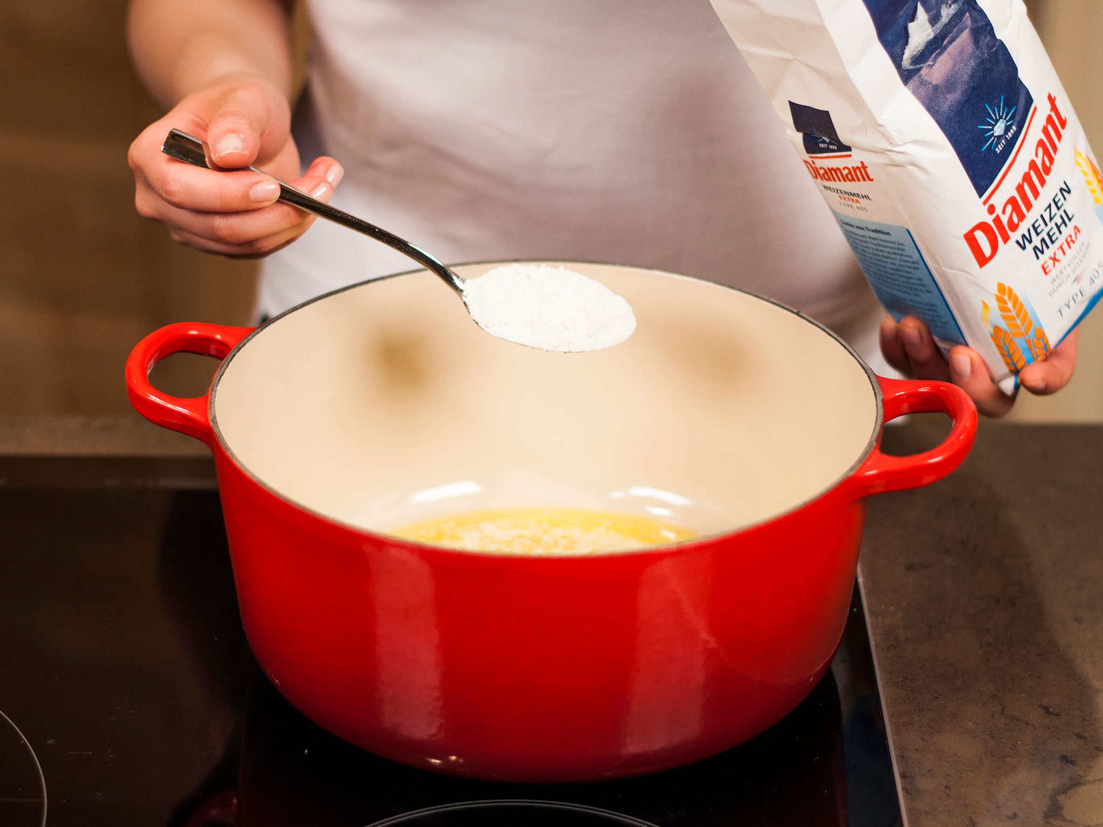 Den Ofen auf 200°C für die Lasagne vorheizen. Für die Béchamelsoße, die Butter in einem kleinen Topf schmelzen. Mehl dazugeben und unter Rühren anrösten.