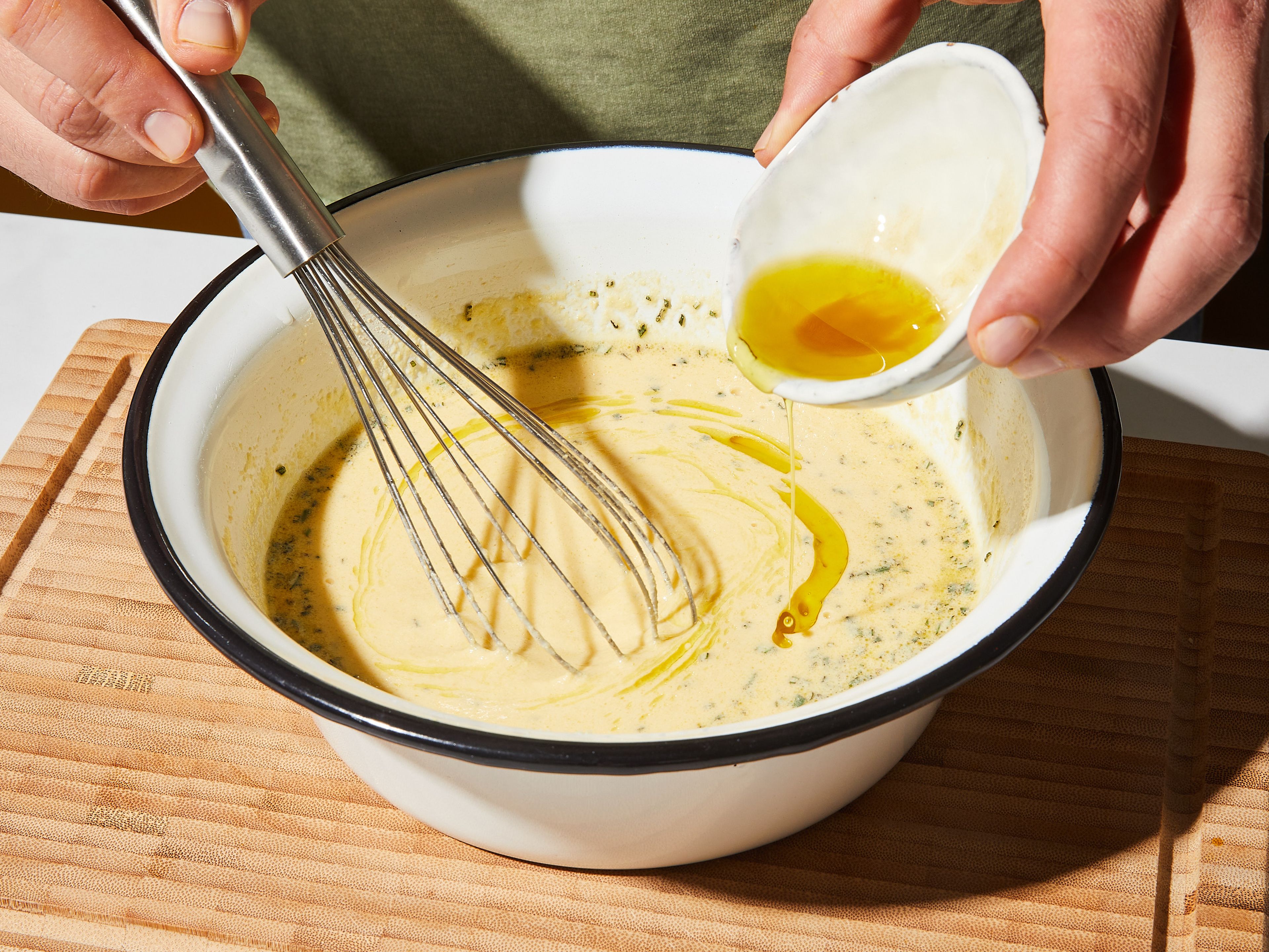 After having rested for 30 min., whisk the batter again and let rest for approx. 30 min. more. During this time, some foam will form on top of the batter. Skim off the foam with a slotted spoon. Add some olive oil and chopped rosemary to the batter and whisk it in until incorporated.