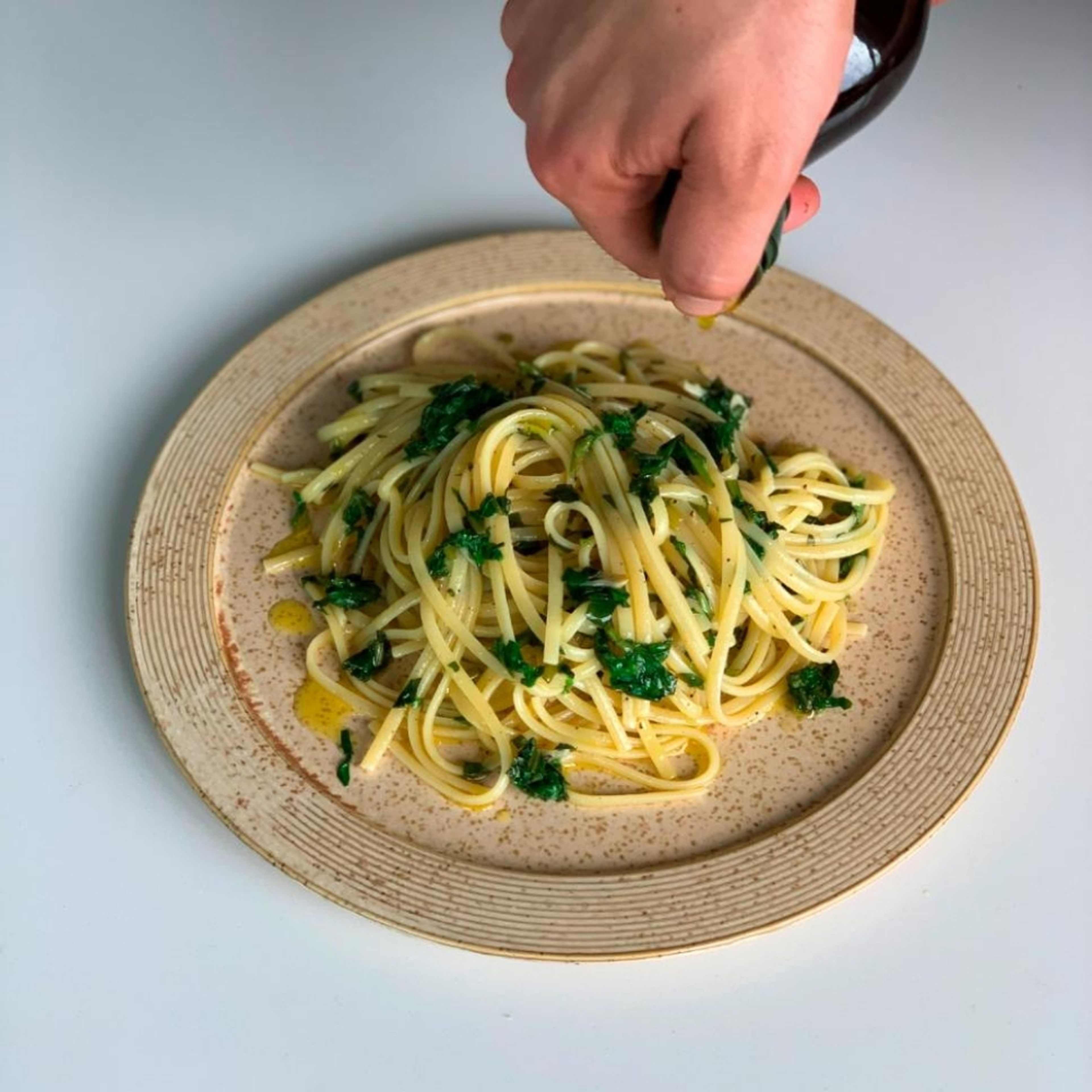 Die Pasta auf einem Teller anrichten,  mit etwas Olivenöl betreufeln und mit Pinienkernen bestreuen.