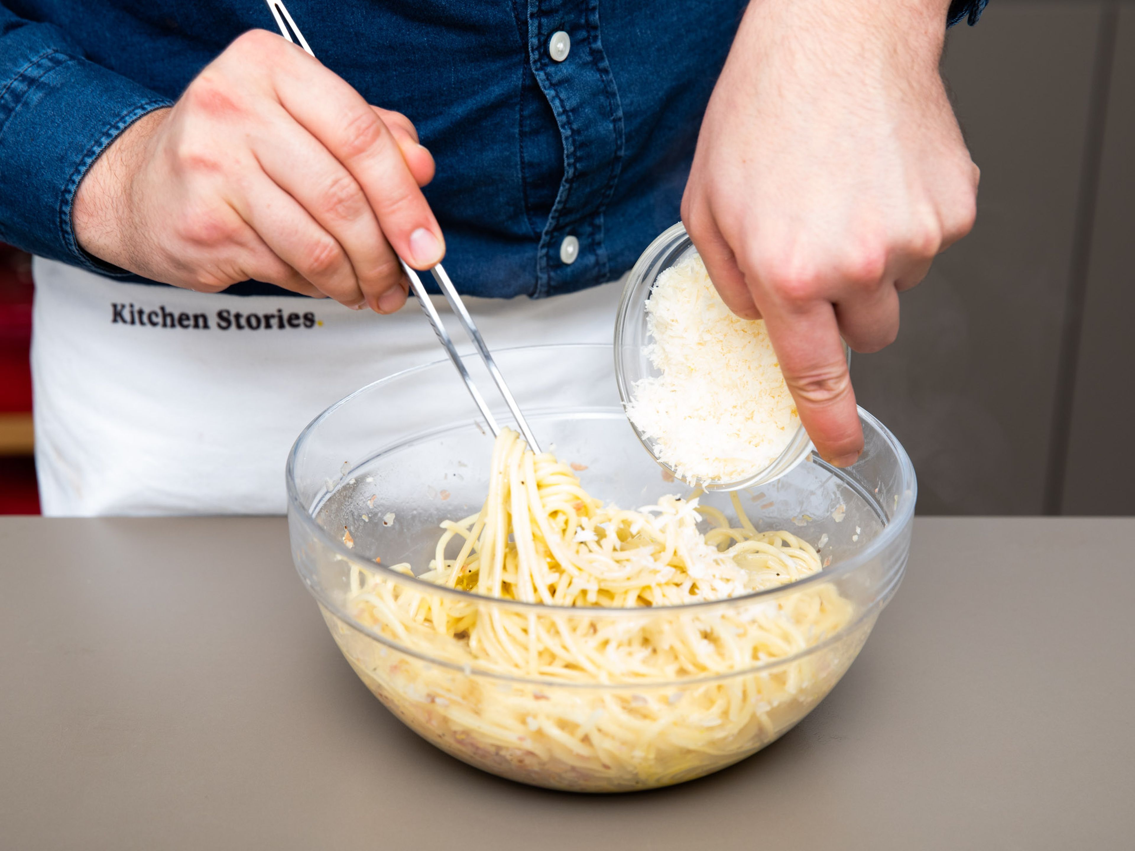 Die Spaghetti zur Schüssel mit geriebenem Parmesan und Eiern geben und mit einer Zange vermengen. Dabei soviel Kochwasser wie nötig dazugeben, bis eine glatte Soße entsteht, die die Nudeln ummantelt. Zitronensaft dazugeben und erneut vermengen.